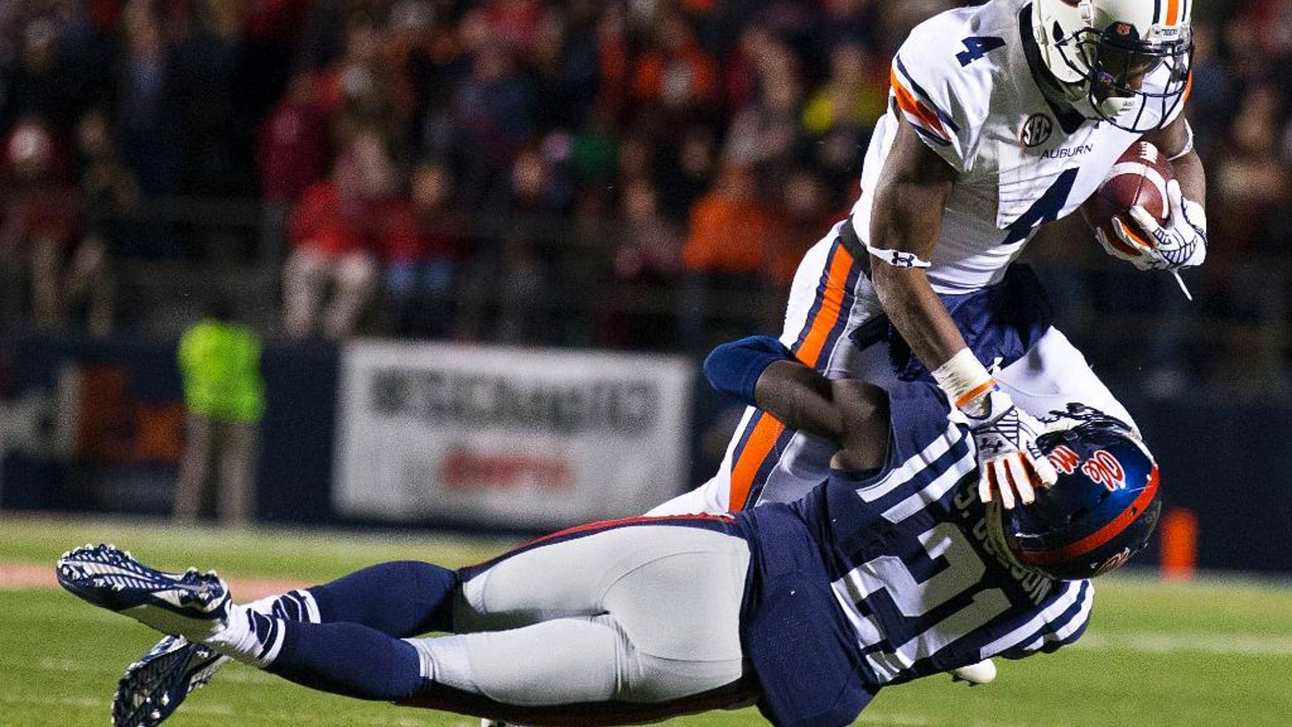 10ThingstoSeeSports - Mississippi defensive back Senquez Golson (21) tackles Auburn wide receiver Quan Bray (4) during the second half of an NCAA college football game Saturday, Nov. 1, 2014, in Oxford, Miss. (AP Photo/Brynn Anderson, File)