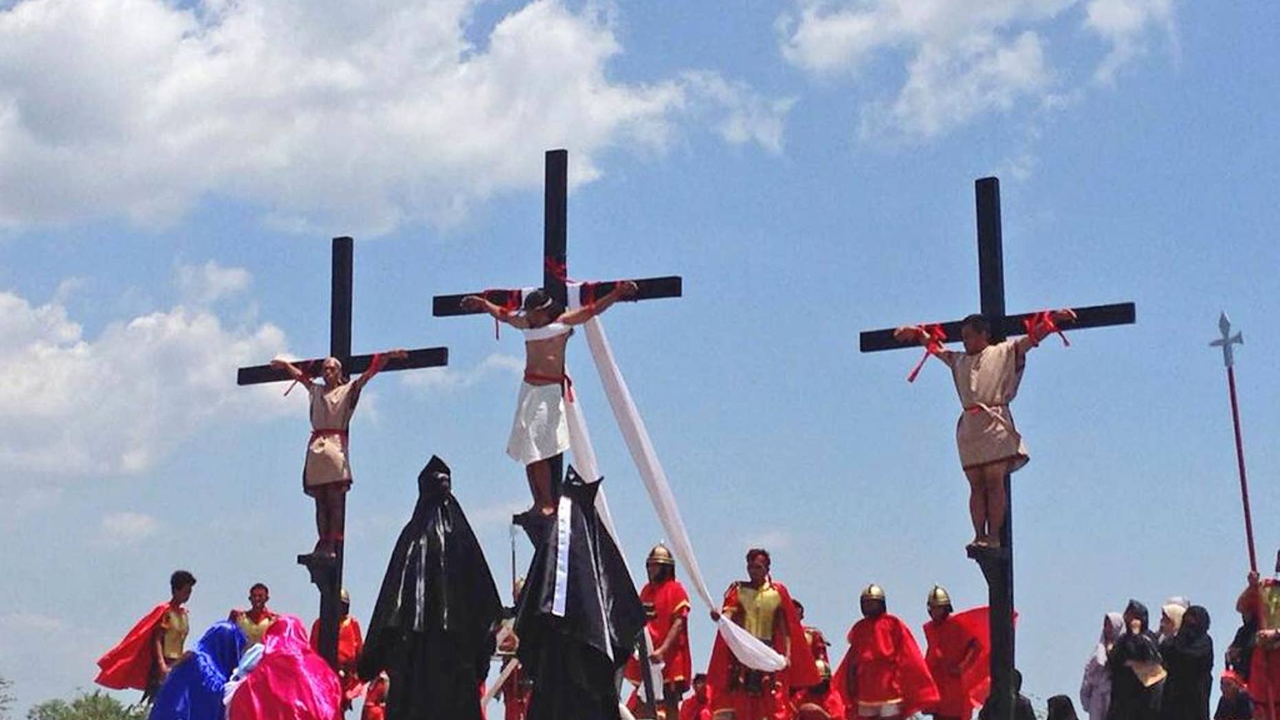Filipino penitents on wooden crosses take part in a reenactment during Good Friday rituals on Friday, April 14, 2017 at Cutud, Pampanga province, northern Philippines. They were remembering Jesus Christ's suffering and death. (AP Photo/Vicente Gonzales)