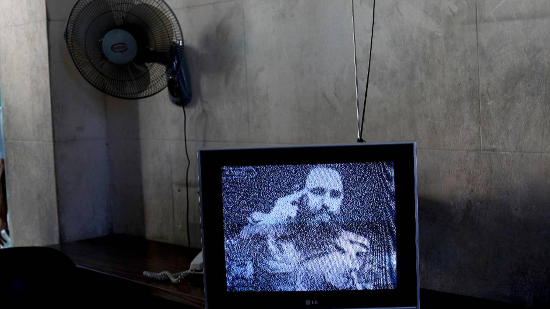 FILE - This Nov. 29, 2016 file photo shows a television broadcasting black and white footage of Fidel Castro at a memorial in his honor in Guanabacoa, on the outskirts of Havana, Cuba. With a shaking voice, President Raul Castro announced on state television that his older brother died Friday evening, Nov. 25. He was 90. (AP Photo/Natacha Pisarenko, File)