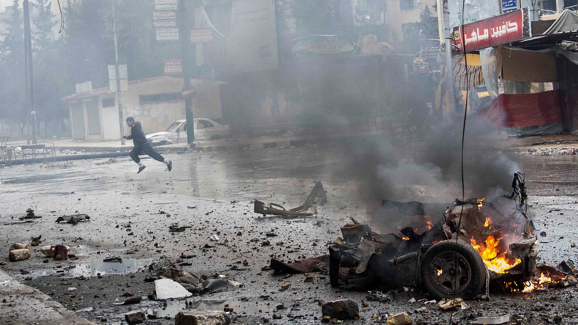In this Monday, Dec. 17, 2012 photo, a boy runs for cover after a mortar shell hit a street killing several people in the Bustan Al-Qasr district of Aleppo, Syria. (AP Photo/Narciso Contreras)