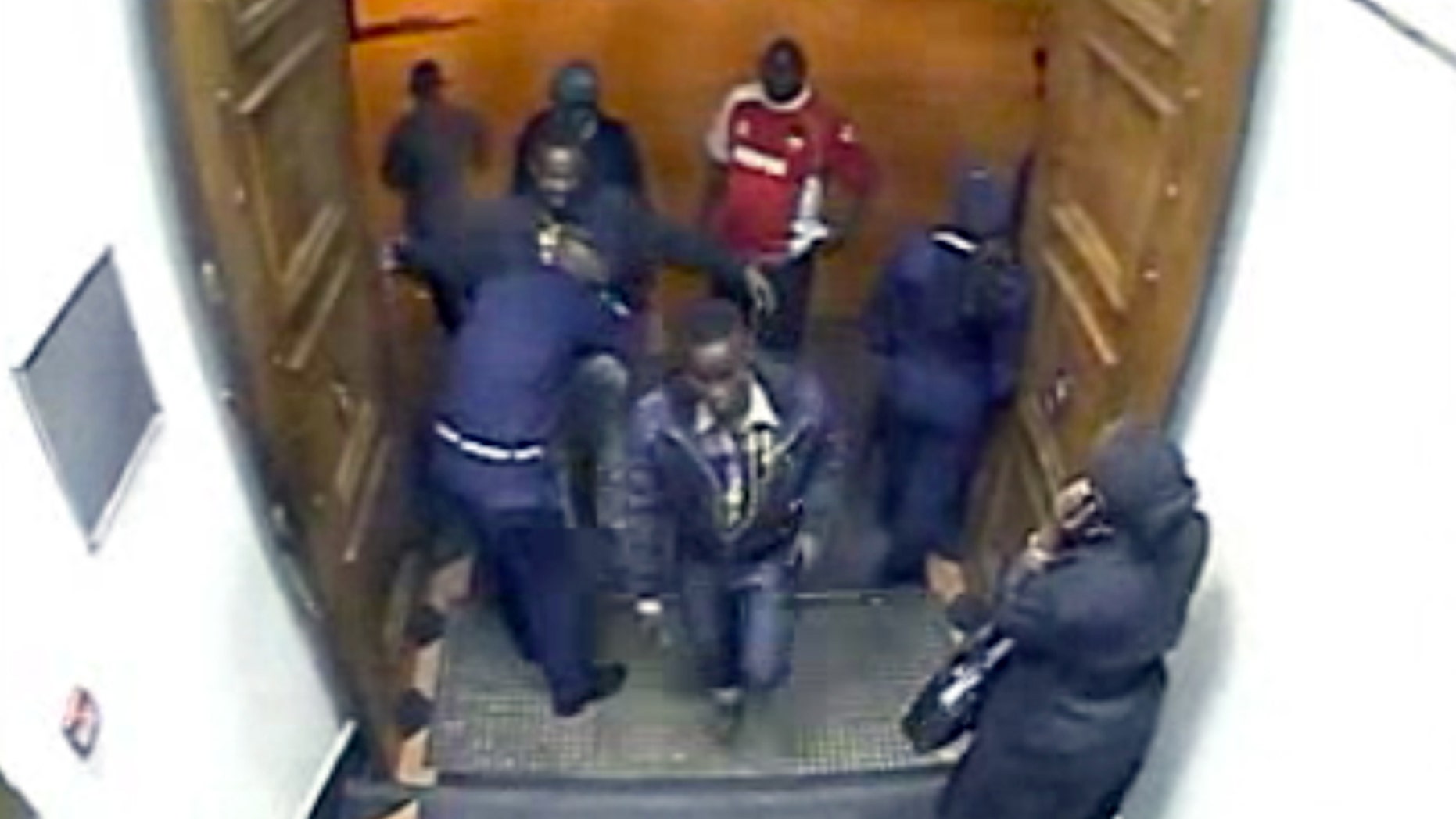In this image from closed circuit television footage released by Kenya's counterterrorism police Sunday, Oct. 6, 2013, two men, one believed to be Adan Dheq, also known as Hussen Abdi Ali, center, and the other, believed to be Abd Kadir Haret Muhamed, also known as Mohamed Hussen, being searched by a guard at left, enter a Barclays Bank branch in Nairobi, Kenya. The men withdrew enough money to pay for a Mitsubishi Lancer car that police say was used to bring the terrorists to the Westgate Mall, indicating the deadly attack was planned weeks in advance, officials said. (AP Photo/APTN)