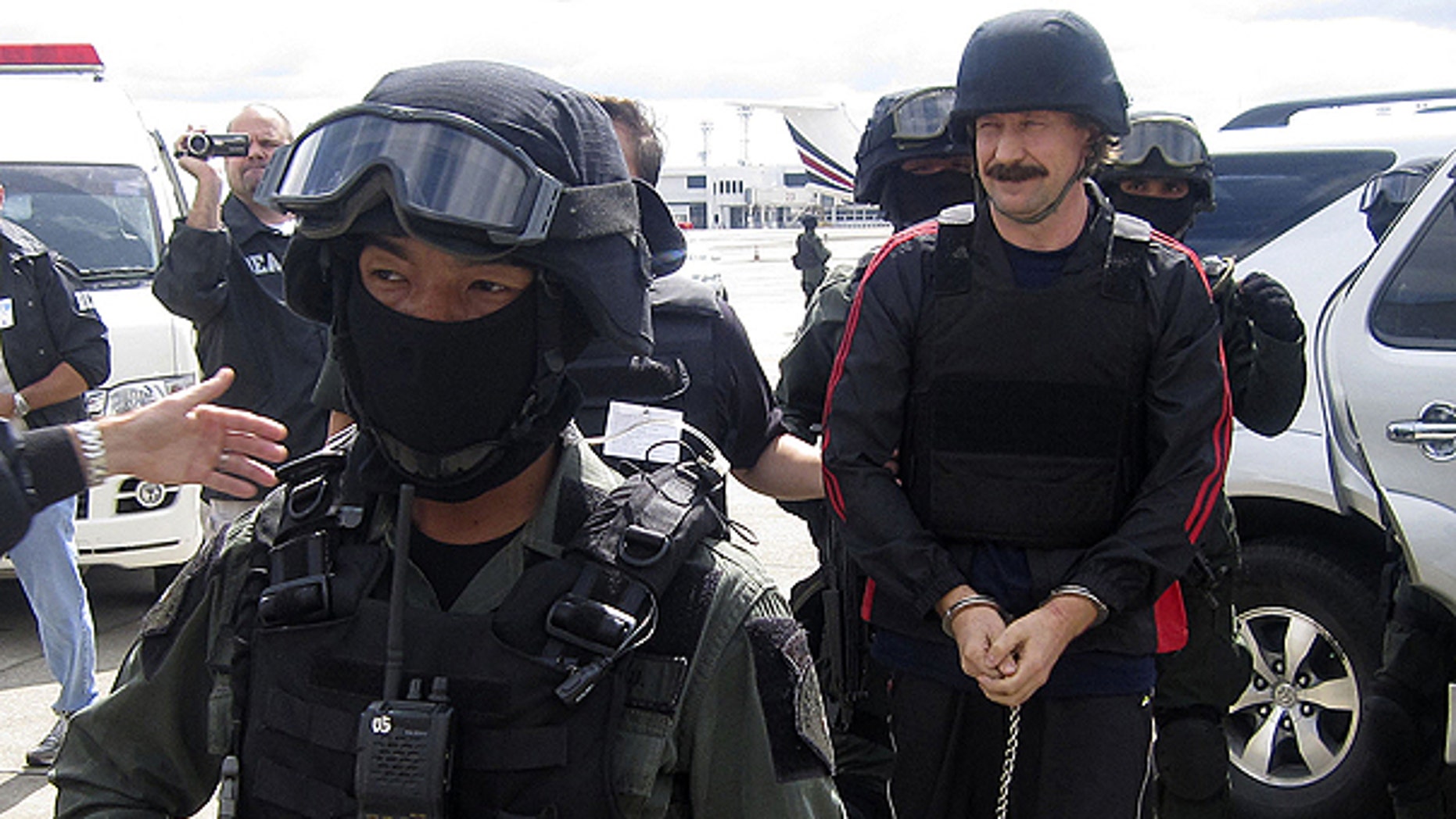 FILE: Russian arms trafficker Viktor Bout, right, escorted by Thai police commandos, arrives at Don muang airport in Bangkok .