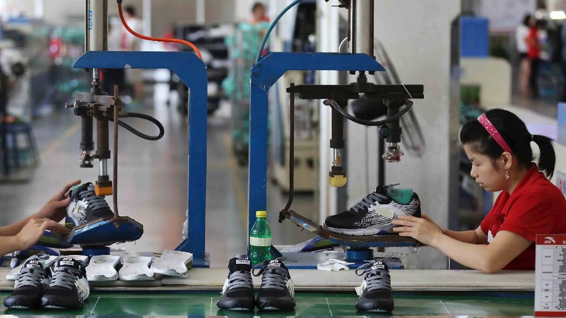 FILE - In this July 27, 2016 file photo, workers assemble sneaker at a factory in Jinjiang city in southeast China's Fujian province. An official survey has found that Chinese factory activity rose again in November to its highest in more than two years. The monthly purchasing managers' index by the Chinese Federation of Logistics and Purchasing released Thursday, Dec. 1, 2016 climbed to 51.7 last month from 51.2 in October. (Chinatopix via AP, File)