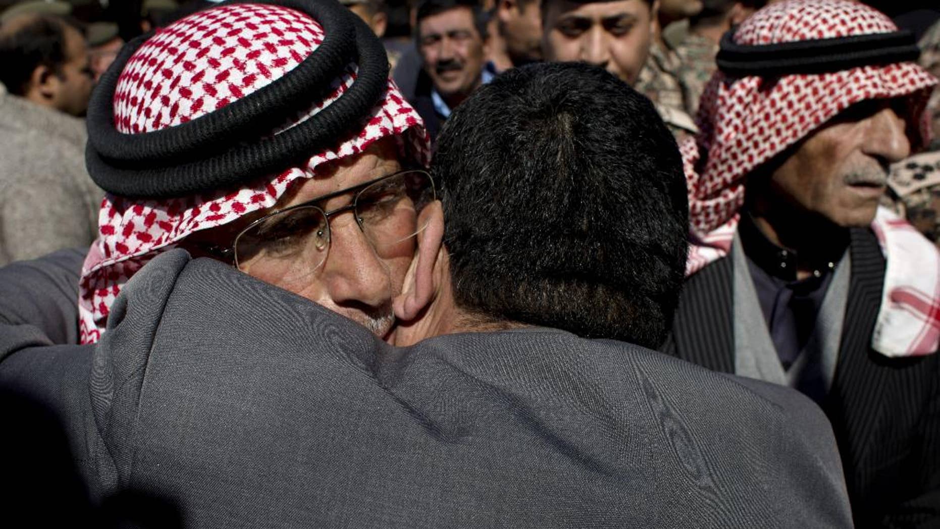 Safi al-Kaseasbeh, left, father of slain Jordanian pilot, Lt. Muath al-Kaseasbeh receives condolences at the Kaseasbeh tribe's gathering divan at their home village of Ai, near Karak, Jordan, Wednesday, Feb. 4, 2015. Outrage and condemnation poured across the Middle East on Wednesday as horrified people learned of the video purportedly showing the Islamic State group burn a Jordanian pilot to death. (AP Photo/Nasser Nasser)