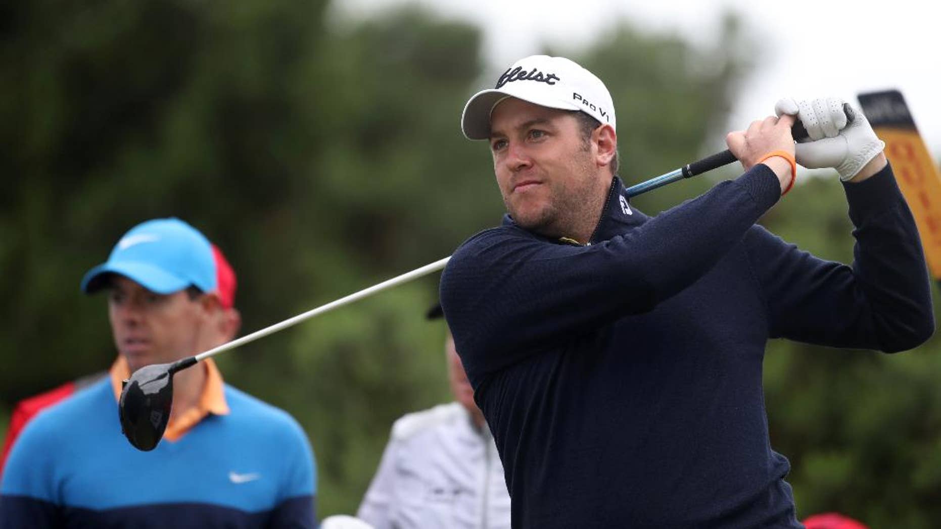 Matthew Southgate of England, right, plays his shot on the 12th tee, watched by Rory McIlroy of Northern Ireland, during a practice round for the British Open Golf Championships at the Royal Troon Golf Club in Troon, Scotland, Tuesday, July 12, 2016. (AP Photo/Peter Morrison)