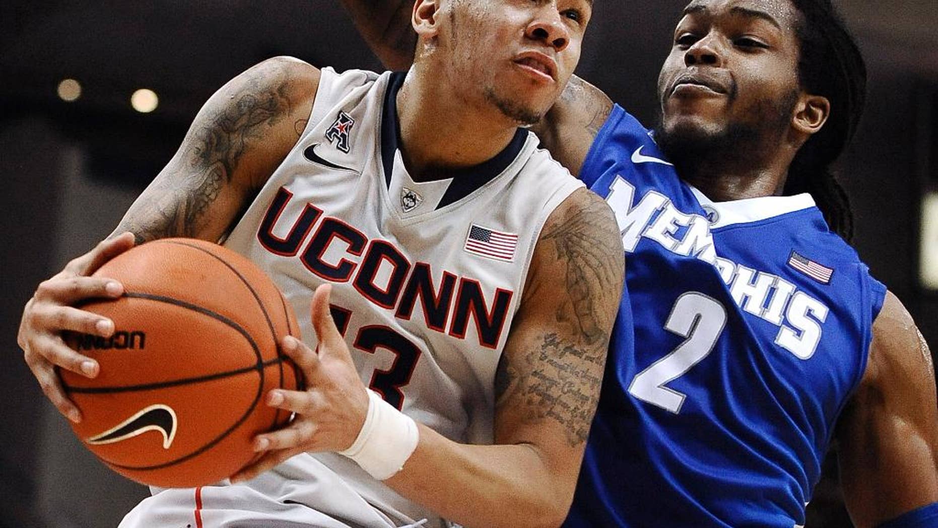 FILE - In this Feb. 15, 2014 file photo, Connecticut's Shabazz Napier, left, drives to the basket as Memphis' Shaq Goodwin defends during the second half an NCAA college basketball game in Hartford, Conn. Napier was selected to The Associated Press All-America team, released Monday, March 31, 2014. (AP Photo/Jessica Hill, FIle)