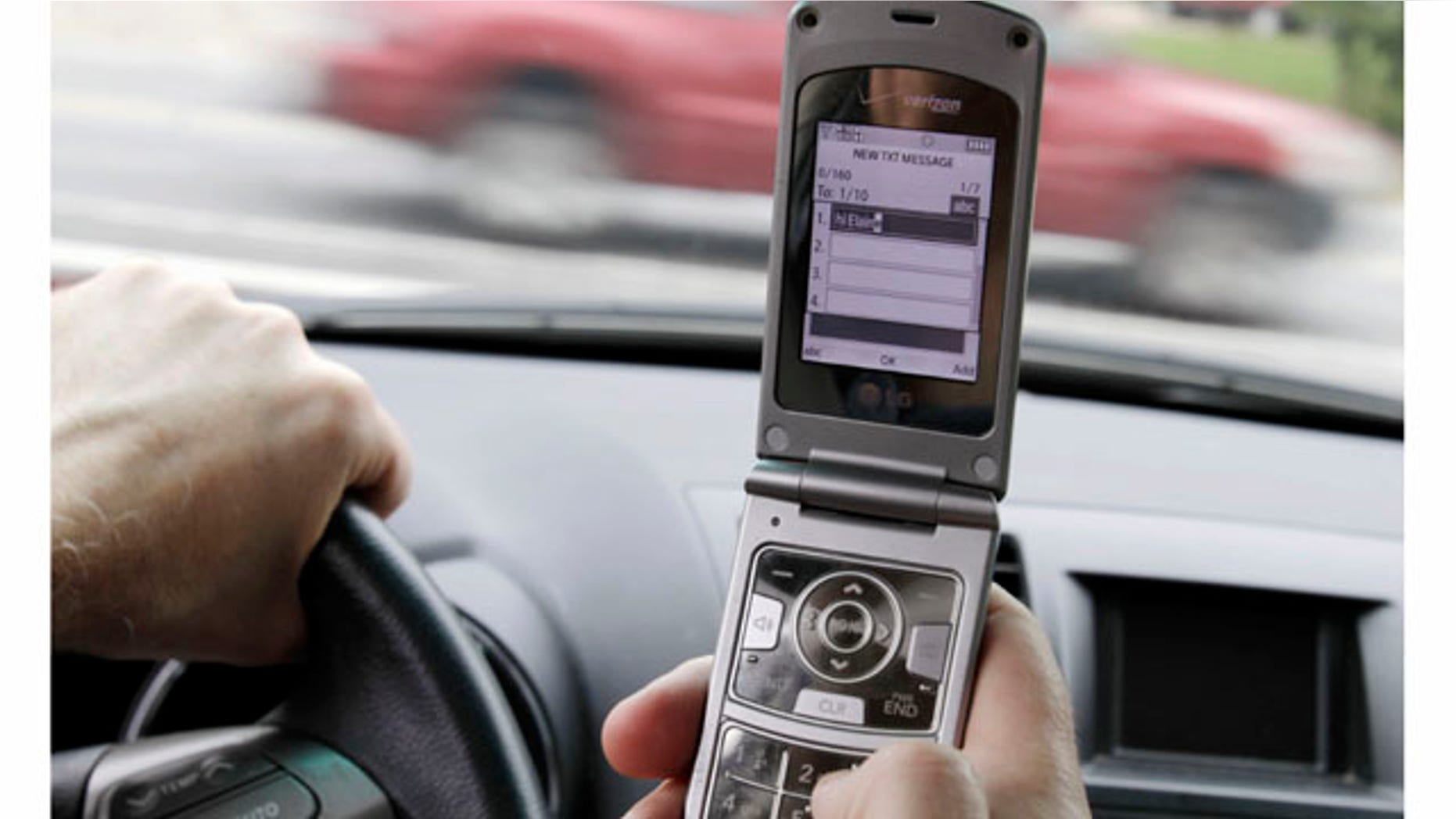 FILE - In this Sept. 20, 2011 file photo, a phone is held in a car in Brunswick, Maine. Texting while driving increased 50 percent last year and two out of 10 drivers say they've sent text messages or emails while behind the wheel despite a rush by states to ban the practice, the National Traffic Safety Administration said Thursday. (AP Photo/Pat Wellenbach, File)
