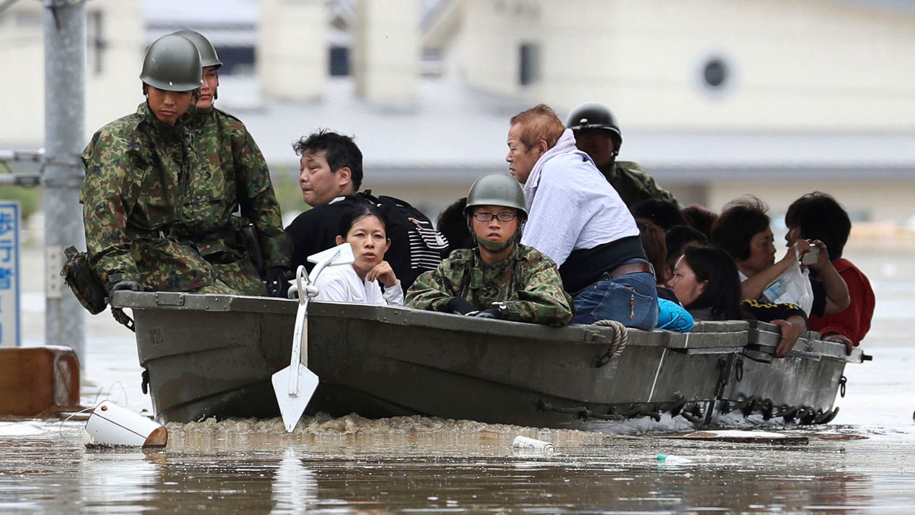 Japan Ground Self-Defense Force members use a boat to evacuate residents from a flooded area caused by heavy rains in Kurashiki, Okayama prefecture