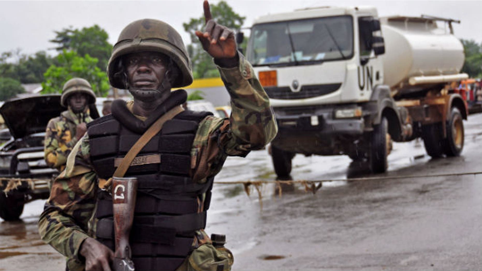 A Liberian soldiers stops people at a security checkpoint setup to lamp down on people traveling due to the Ebola virus, on the outskirts of Monrovia, Liberia, Thursday, Aug. 7, 2014. (AP Photo/Abbas Dulleh)