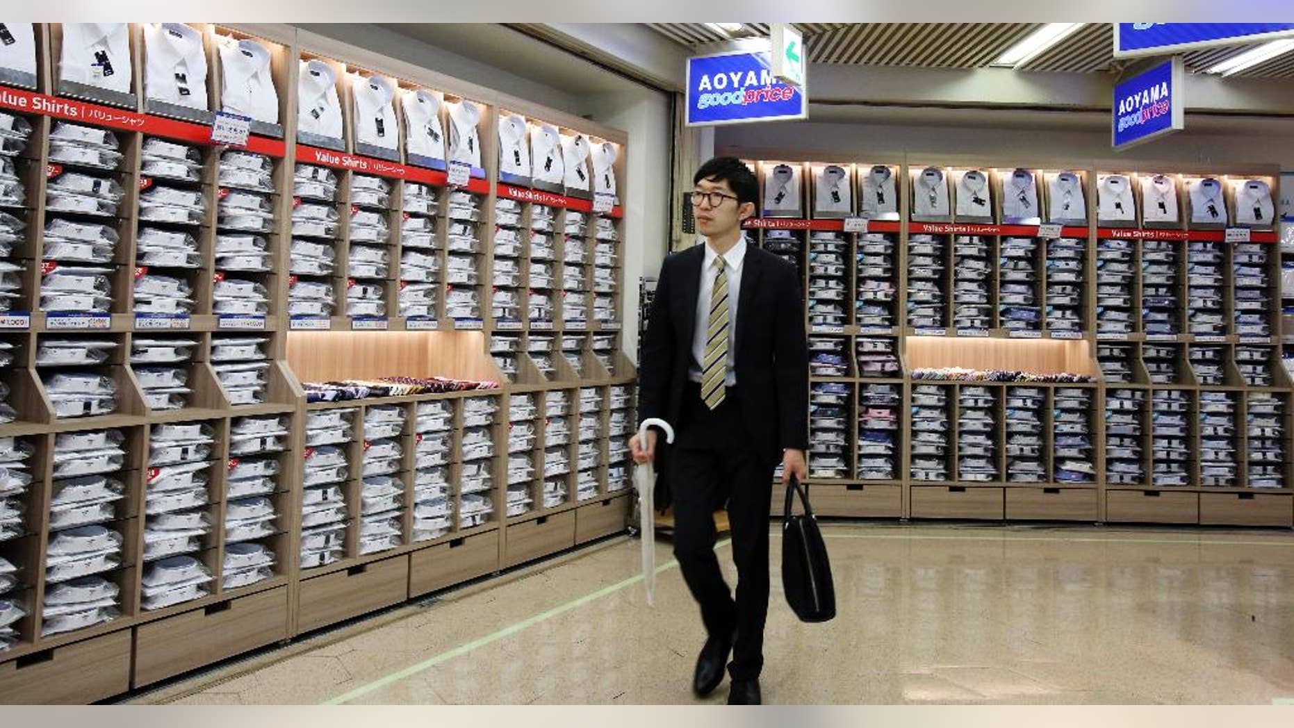In this June 26, 2015 photo, a man walks past the shelves of shirts in Tokyo. Japan’s economy contracted at a minus 1.2 percent annual rate in the April-June quarter, on higher than earlier estimated inventories and consumer demand. The revised growth figure released Tuesday, Sept. 8, 2015 was better than some economists had anticipated. (AP Photo/Koji Sasahara)