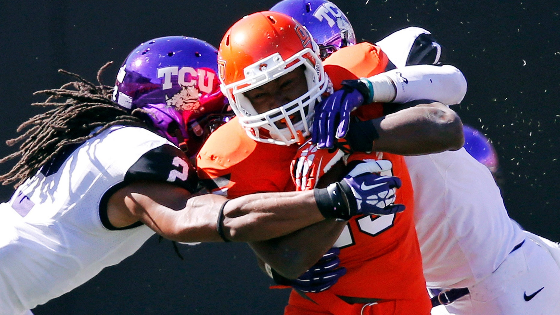 FILE - In this Oct. 19, 2013, file photo, Oklahoma State running back Rennie Childs (23) fights off a tackle by TCU cornerback Jason Verrett (2) and safety Chris Hackett (1) during the fourth quarter of an NCAA college football game in Stillwater, Okla. Childs provided Oklahoma State with a much-needed boost on the ground in last week's win over TCU. The running back could be counted on again this week when the Cowboys travel to Iowa State. (AP Photo/Sue Ogrocki, File)
