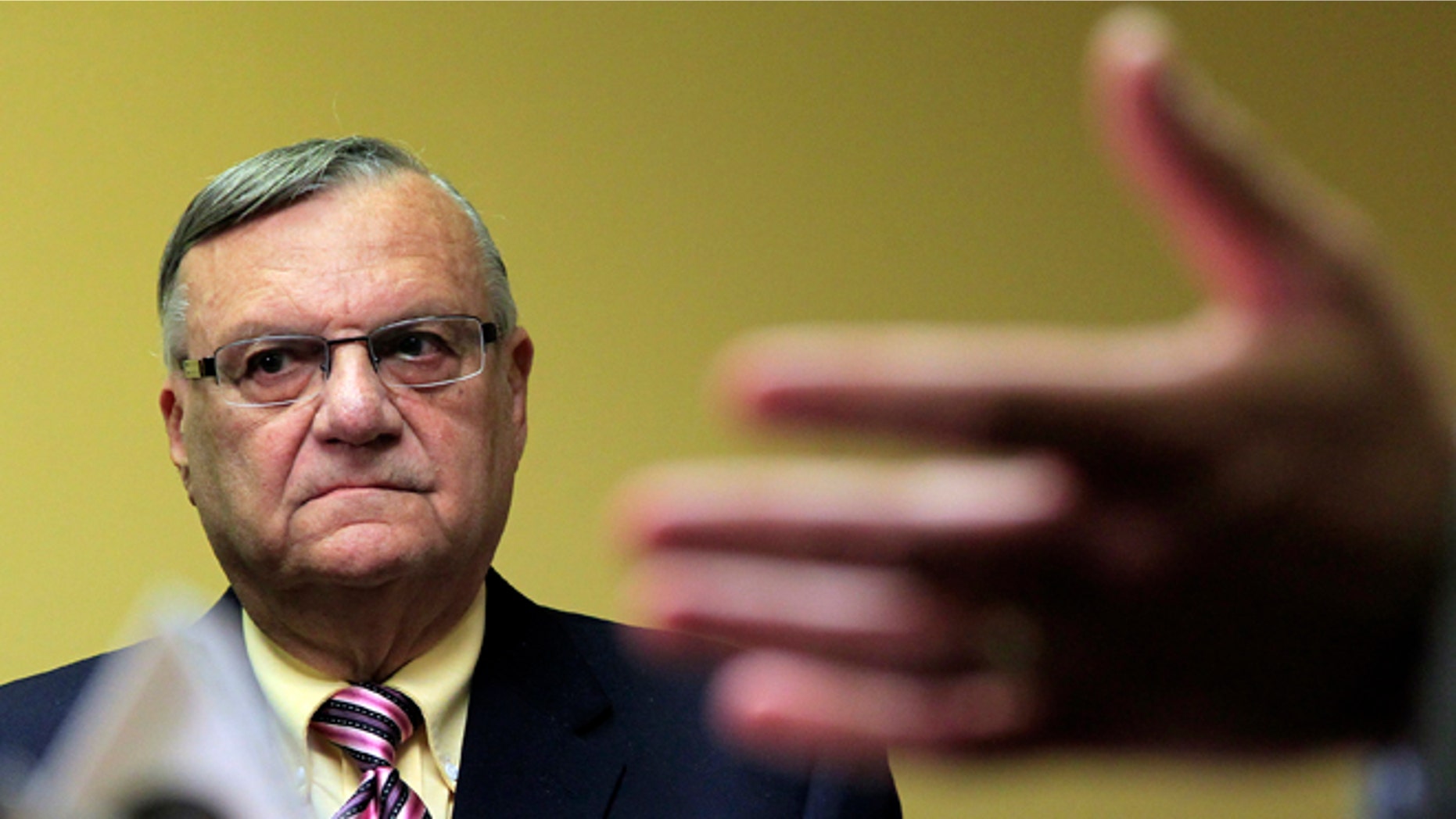 FILE - In this April 3, 2012 file photo, Maricopa County Sheriff Joe Arpaio listens to one of his attorneys during a news conference in Phoenix. Arpaio, who led the way for local police across the country to take up immigration enforcement, is reconsidering his crackdowns _ and other law enforcement officials who followed his lead are expected to eventually back away, too. (AP Photo/Ross D. Franklin, File)