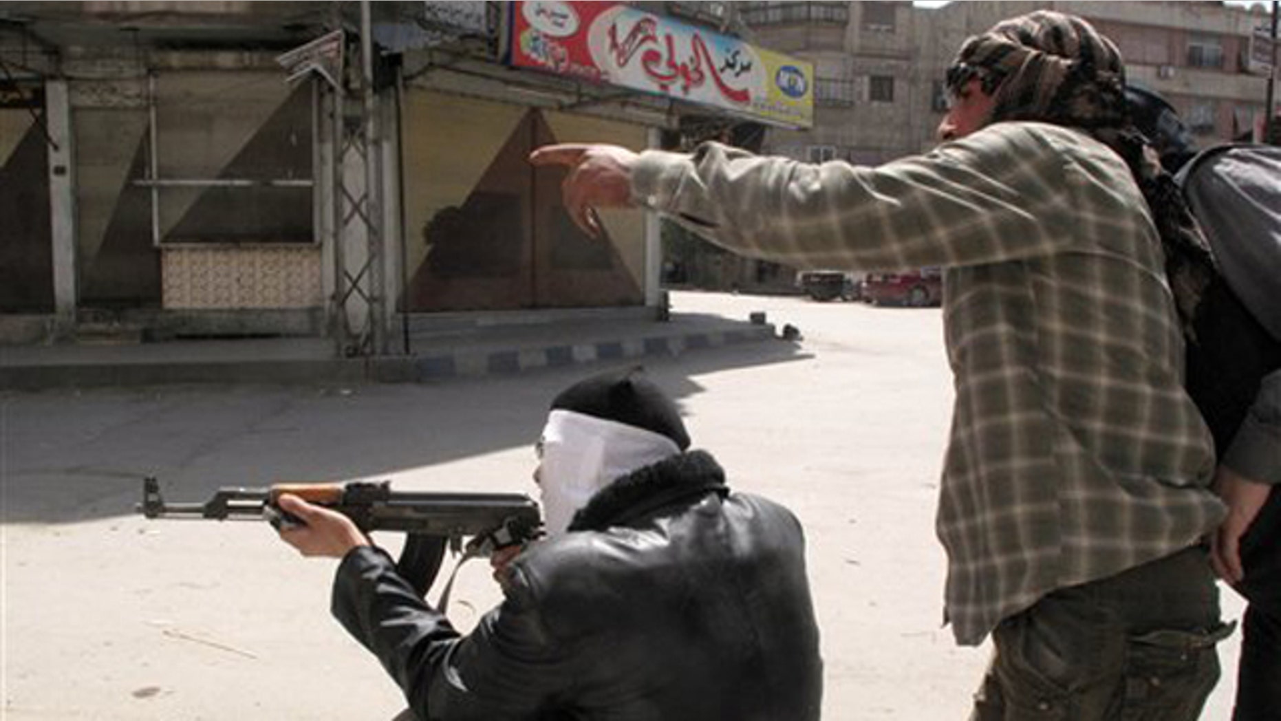April 6, 2012: In this photo, Free Syrian Army fighters try to spot a sniper during fighting with Syrian troops in a suburb of Damascus, Syria.