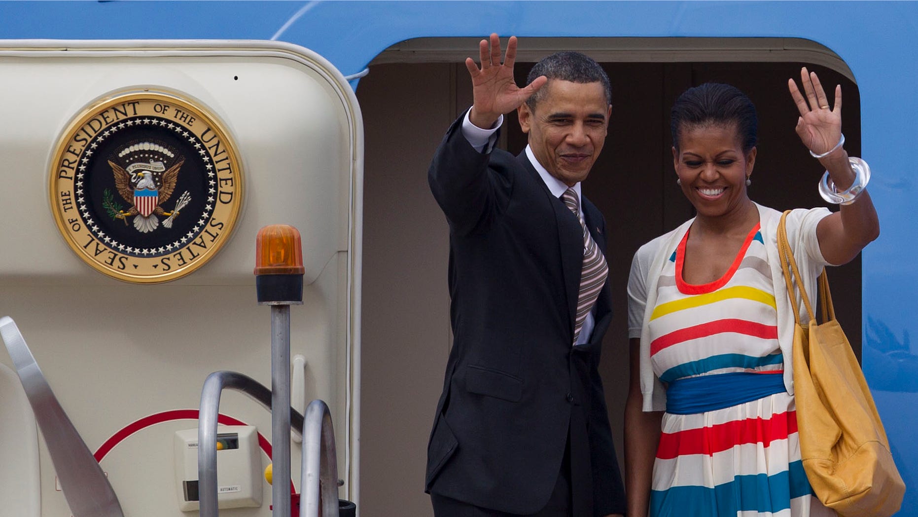 President Barack Obama, left, and his wife first lady Michelle Obama wave as they leave Rio de Janeiro, Brazil, Monday, March 21, 2011. Obama and his family flew to Santiago, Chile, on Monday morning. (AP Photo/Felipe Dana)