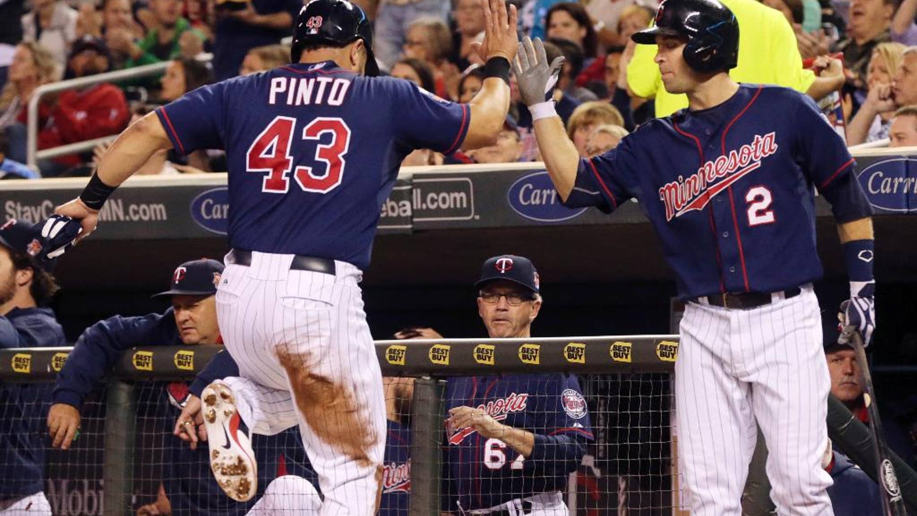 Minnesota Twins' Josmil Pinto, left, is congratulated by Brian Dozier after he scored on a single by Minnesota Twins' Eduardo Escobar off Arizona Diamondbacks pitcher Andrew Chafin in the second inning of a baseball game, Tuesday, Sept. 23, 2014, in Minneapolis. (AP Photo/Jim Mone)
