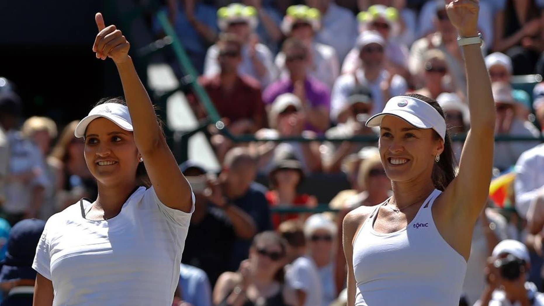 Martina Hingis of Switzerland, right celebrates with partner Sania Mirza of India as they win their women's semifinal doubles match against Raquel Kops-Jones of the United States and Abigail Spears of the United States, at the All England Lawn Tennis Championships in Wimbledon, London, Friday, July 10, 2015. Hingis and Mirza won the match 6-1, 6-2. (AP Photo/Alastair Grant)