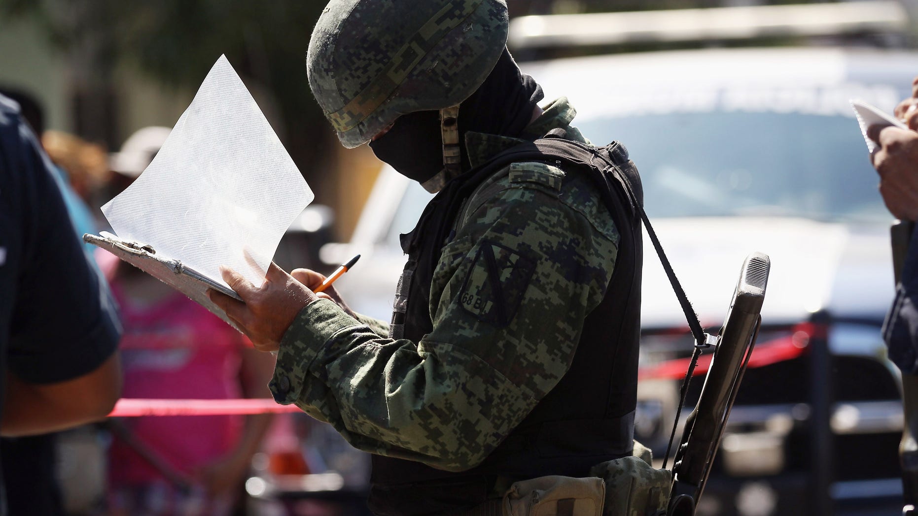 ACAPULCO, MEXICO - MARCH 02: A Mexican army soldier takes notes at the site of a suspected drug-related double execution on March 2, 2012 in Acapulco, Mexico. Drug violence has surged in the coastal resort in the last year, making Acapulco the second most deadly city in Mexico after Juarez. One of Mexico's top tourist destinations, Acapulco has suffered a drop in business, especially from foreign tourists, due to the violence. Toursim accounts for about 70 percent of the economy of Acapulco's state of Guerrero and 9 percent of Mexico's economy. (Photo by John Moore/Getty Images)