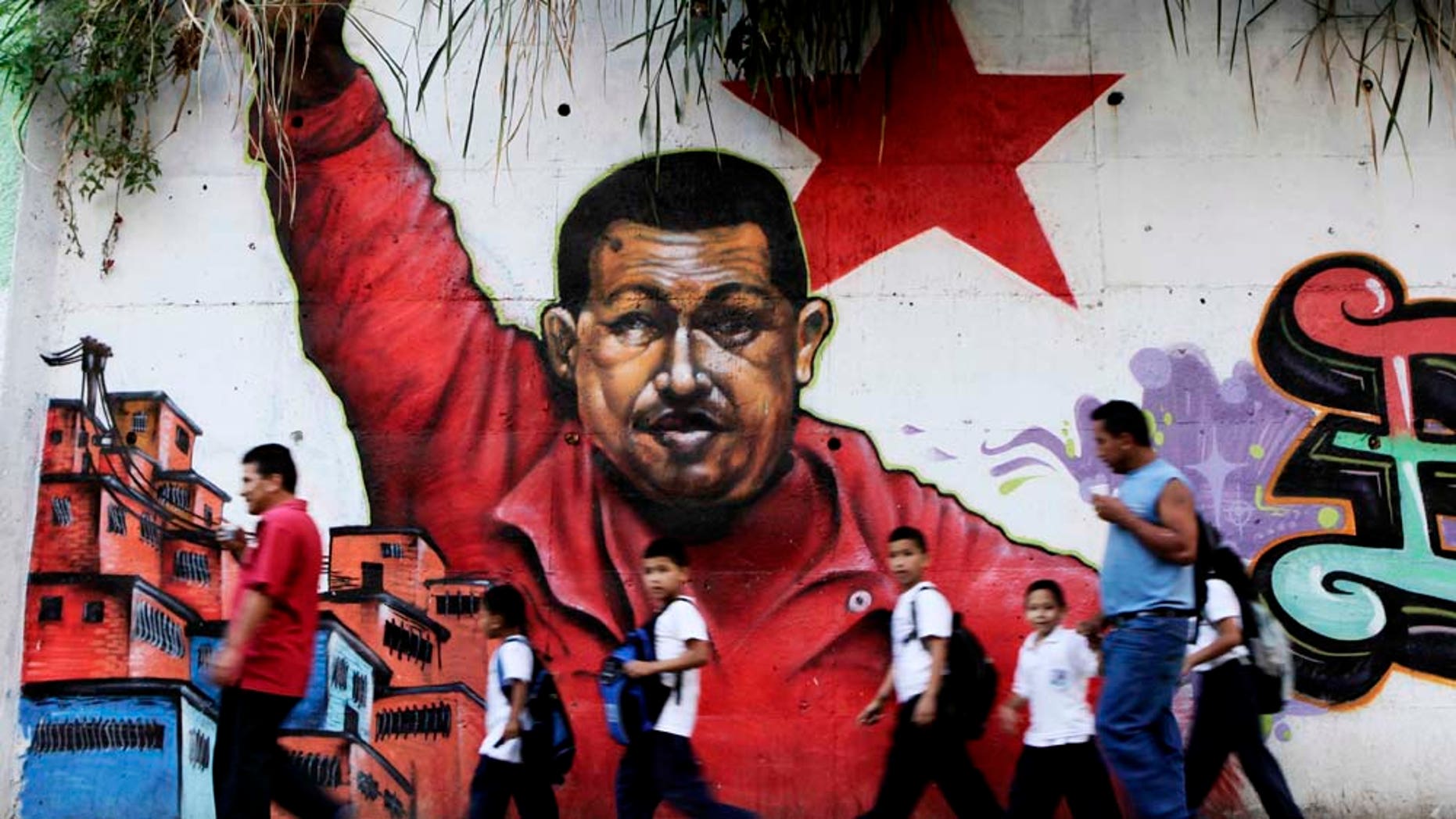 People pass in front a mural depicting Venezuelaâs President Hugo Chavez in Caracas, Venezuela, Wednesday, Feb. 2, 2011. Chavez celebrated his 12th anniversary in power Wednesday saying he is ready to battle for six more years in next year's election. (AP Photo/Ariana Cubillos)