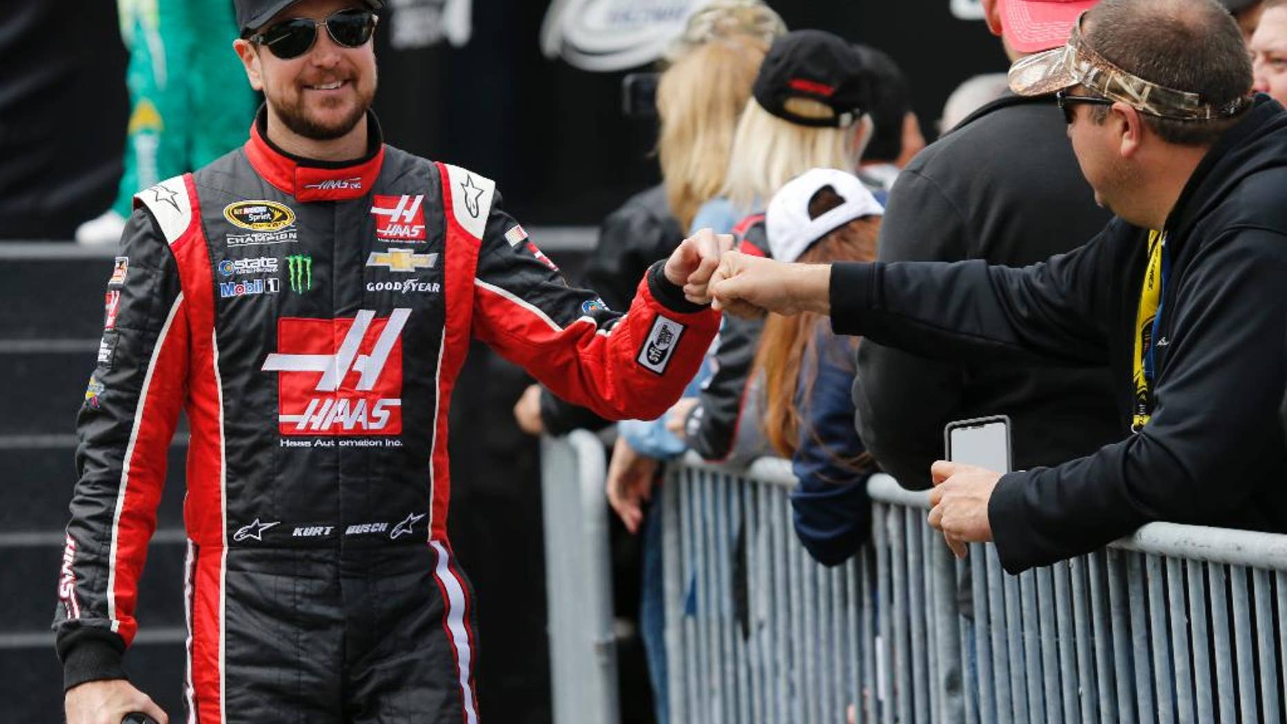 Kurt Busch fist-bumps a fan prior to the NASCAR Sprint Cup auto race at Richmond International Raceway in Richmond, Va., Sunday, April 26, 2015. (AP Photo/Steve Helber)
