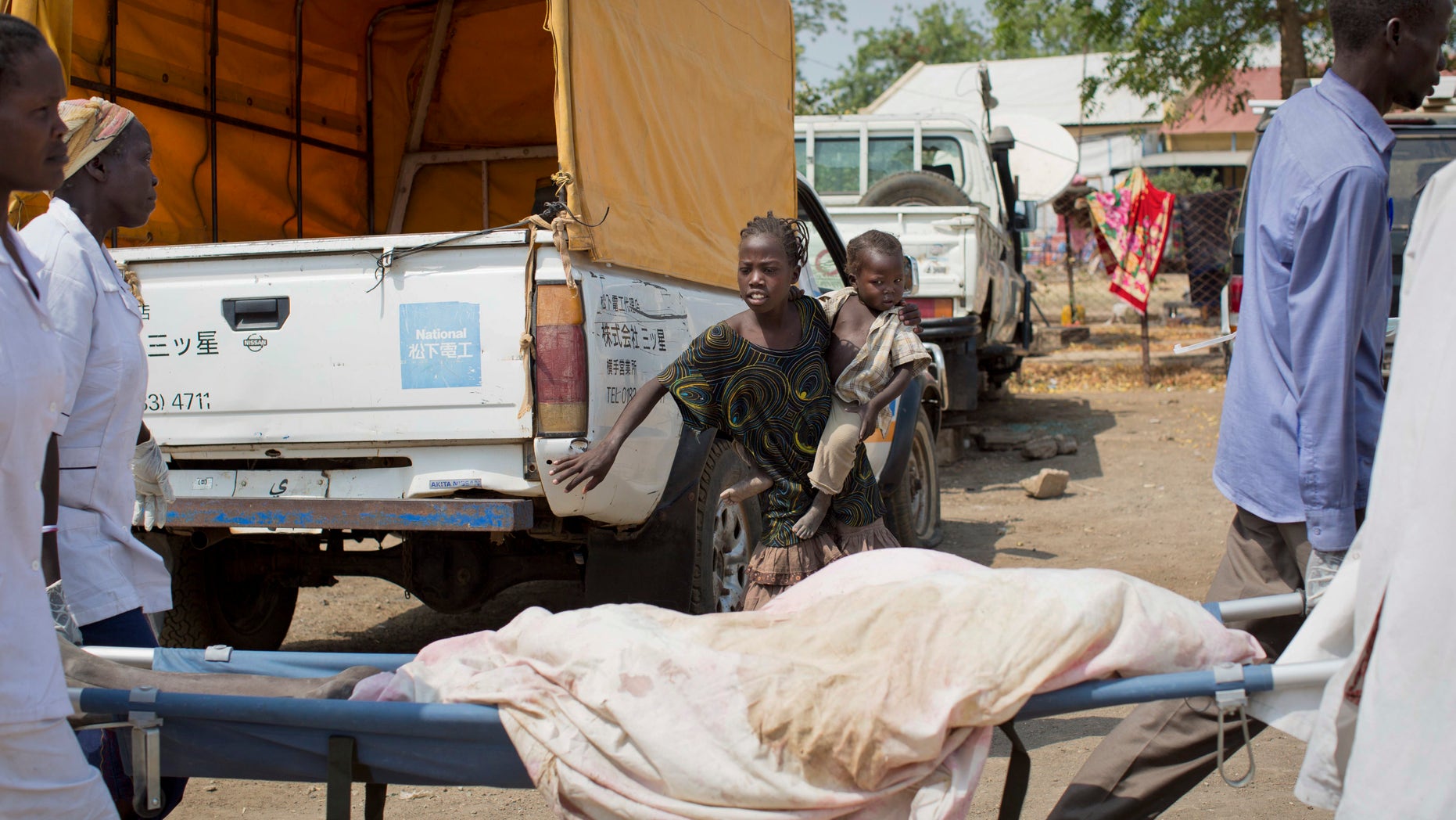A young girl steps back as hospital staff carry past the body of a young boy who was killed by a gunshot the day before, at the teaching hospital in Malakal, Upper Nile State, in South Sudan Tuesday, Jan. 21, 2014. The government said Monday that it had regained control of Malakal, the capital of the oil-producing Upper Nile state, though the U.N. said its base there took fire, wounding nearly three dozen people and damaging the hospital. (AP Photo/Mackenzie Knowles-Coursin)