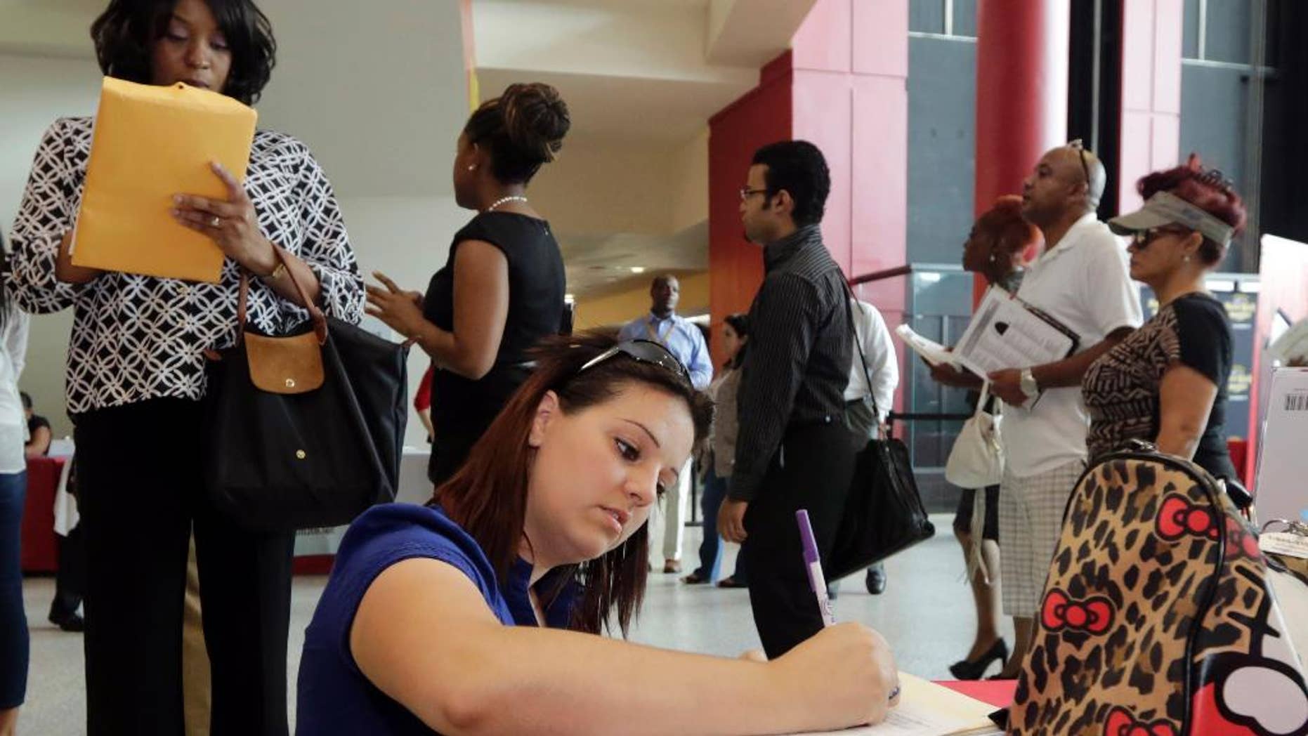 In this photo taken Tuesday, Aug. 19, 2014, Jessica Pimentel, of Hollywood, Fla., fills out a job application during a job fair in Sunrise. Fla. The Labor Department releases weekly jobless claims on Thursday, Aug. 28, 2014. (AP Photo/Alan Diaz)