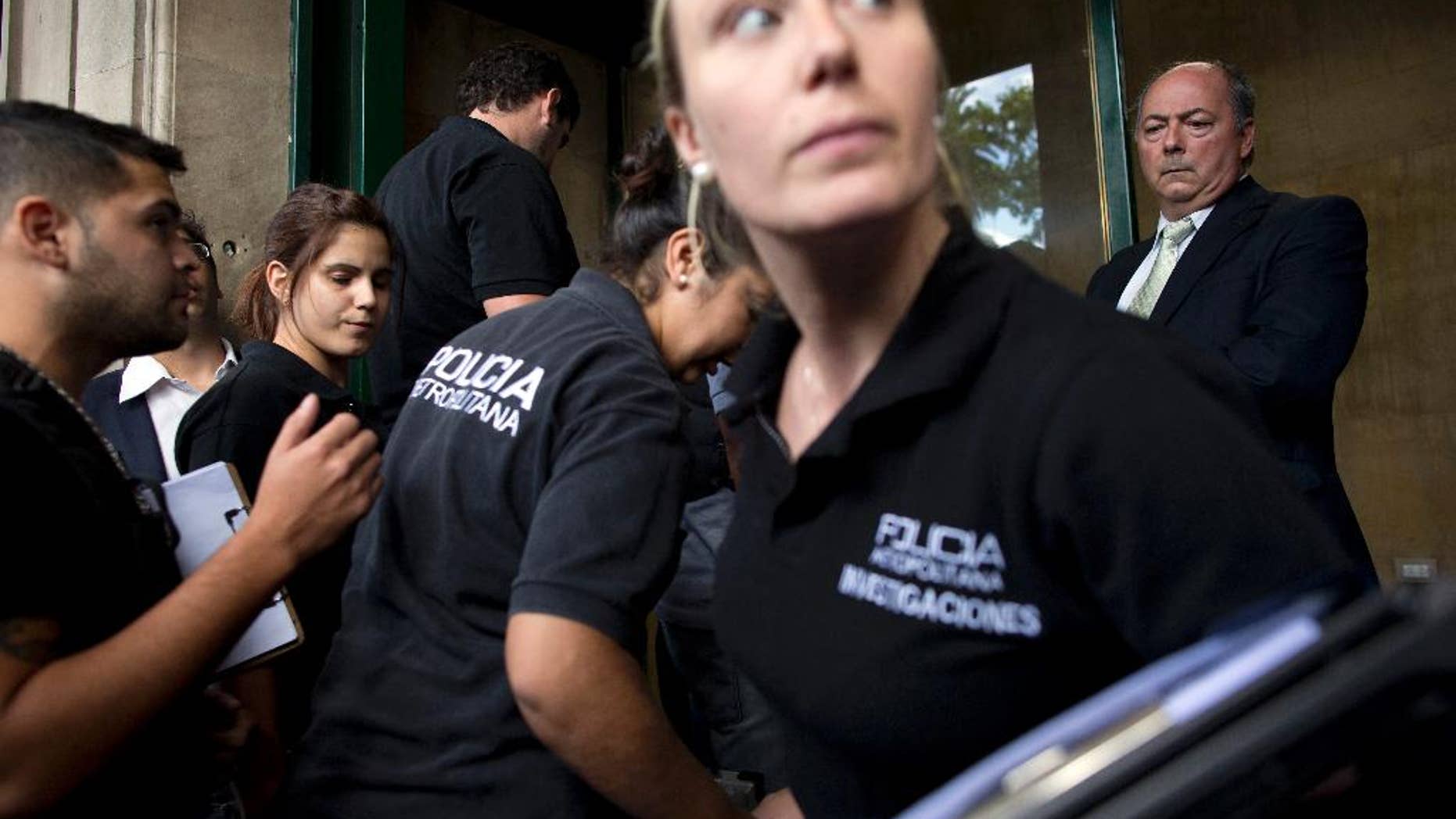 FILE - In this Tuesday, Jan. 20, 2015, file photo, police enter the building where late prosecutor Alberto Nisman had his office, to gather evidence for the investigation into his death in Buenos Aires, Argentina. Two medical teams are meeting, Wednesday, May 6, 2015, in Argentina's capital in an extraordinary session aimed at concluding whether prosecutor Alberto Nisman killed himself or was slain. The meeting began after months of debate about how Nisman died Jan. 18, when he was found in his bathroom with a bullet in his head. (AP Photo/Rodrigo Abd,File)