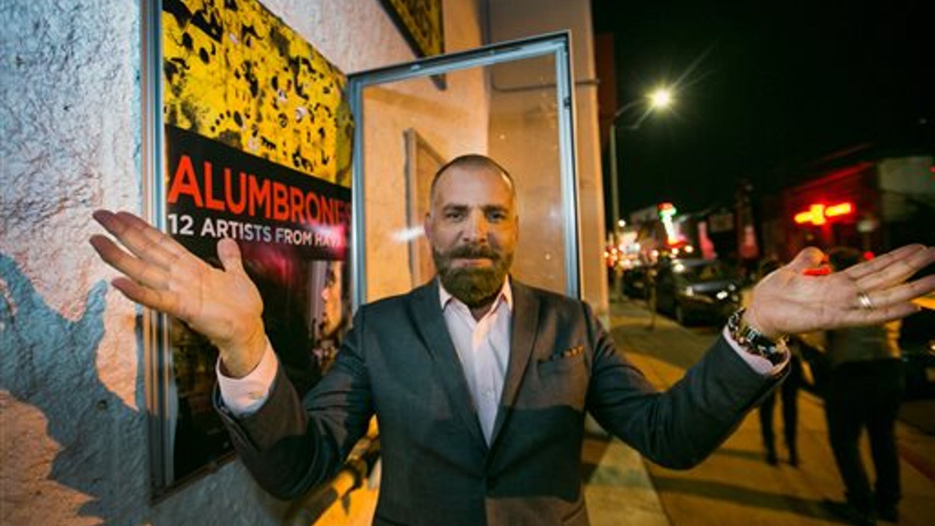 Cuban producer Fermin Rojas poses with the poster of his film, "Alumbrones" in Los Angeles.