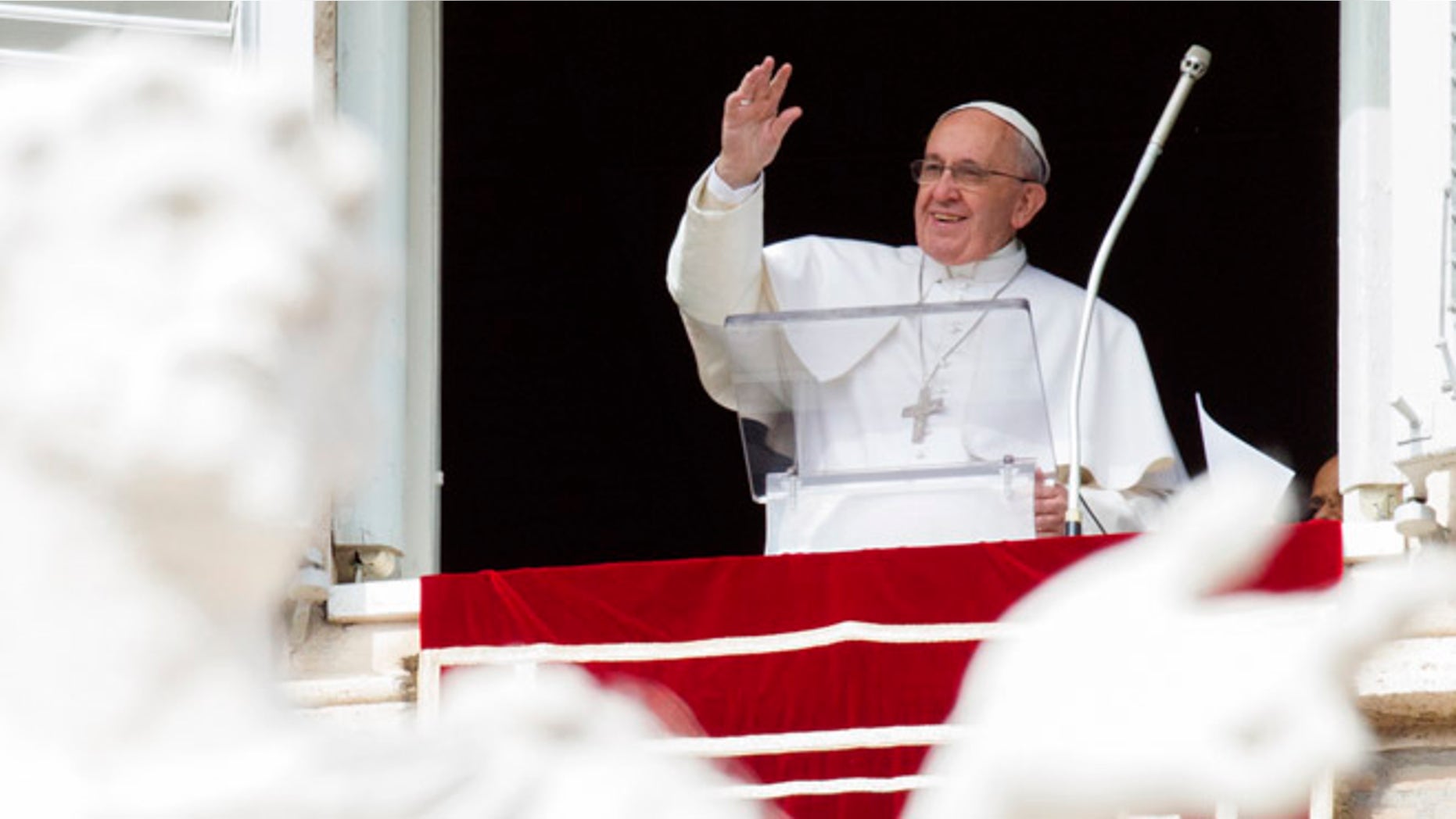 Pope Francis waves to faithful from his studio window overlooking St. Peter's Square, during the Angelus noon prayer at the Vatican, Sunday, Feb. 22, 2015. Francis told tens of thousands of Romans, tourists and pilgrims in St. Peter's Square that later Sunday he and top aides were starting a spiritual renewal retreat. Until Friday morning, they will spend time listening to reflections, meditating and praying in Ariccia, a Rome suburb. (AP Photo/Riccardo De Luca)