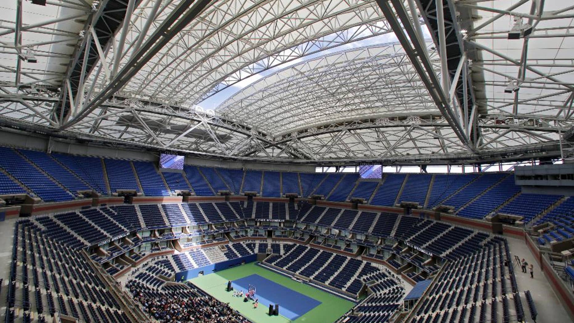 FILE - In this Aug. 2, 2016, file photo, the partially open new retractable roof allows a ribbon of light into Arthur Ashe Stadium at the Billie Jean King National Tennis Center in New York. With the stadium now covered by a retractable roof, players such as defending champ Novak Djokovic wonder how it will affect conditions when it is closed. (AP Photo/Richard Drew, File)
