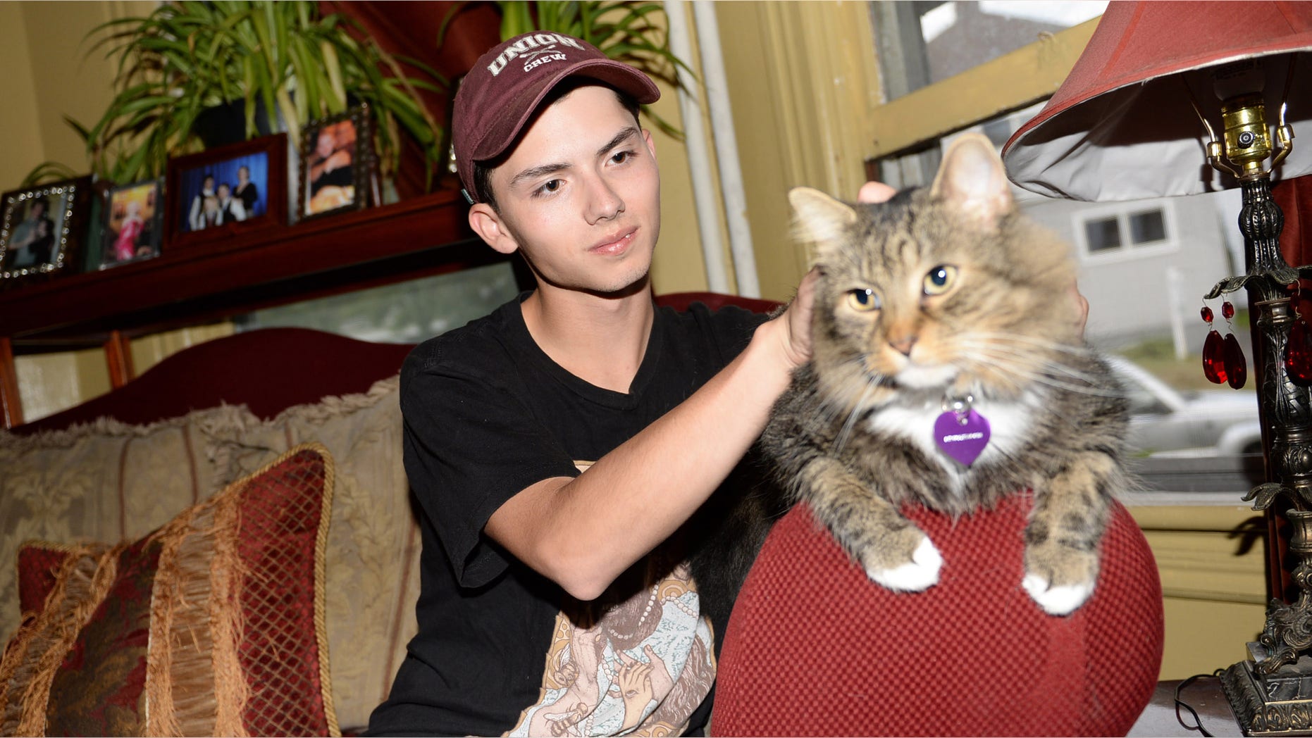 FILE - In a Wednesday, Sept. 10, 2014 file photo, Draven Rodriguez and his cat Mr. Bigglesworth at their home in Schenectady, N.Y. Rodriguezâs parents tell the Times-Union of Albany their son committed suicide Thursday, Feb. 19, 2015 at their Schenectady home. He was 17. Rodriguez had wanted his senior yearbook portrait to show him holding his cat Mr. Bigglesworth, with lasers in the background. The school denied his request but said the photo could appear somewhere in the Schenectady High School yearbook.(AP Photo/The Daily Gazette, Patrick Dodson)