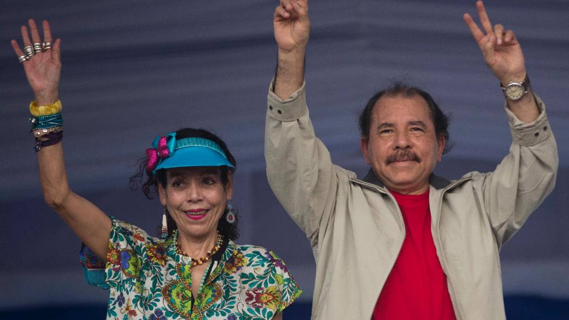 FILE - In this July 3, 2015, file photo, Nicaragua's President Daniel Ortega, right, and first lady Rosario Murillo, wave to supporters during an event commemorating the 36th anniversary of the Sandinista National Liberation Front withdrawal to Masaya, in Managua, Nicaragua. Nicaragua’s governing Sandinista party has named the first lady on Tuesday, Aug. 2, 2016, as the running-mate of President Ortega in his bid for a third term in Nov. 6 election. (AP Photo/Esteban Felix,File)