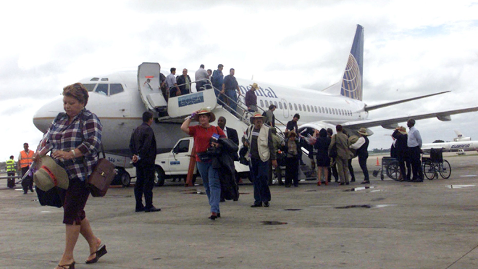 Passengers walk away from a Continental Airlines Boeing-737 at Havana's Jose Marti International Airport. (Photo by Jorge Rey/Getty Images)