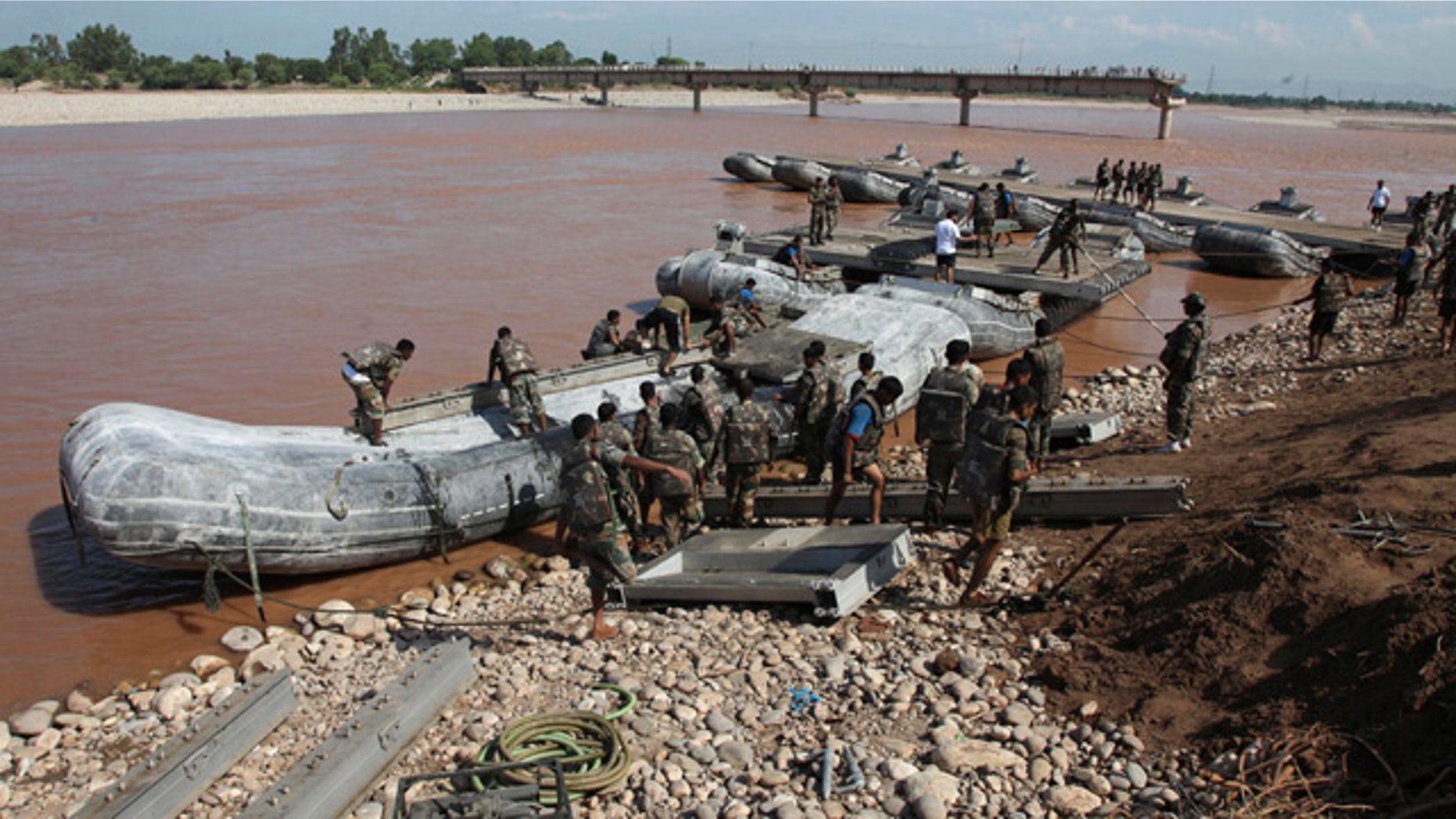 September 9, 2014: Indian army soldiers build a temporary bridge across the Tawi River after the existing bridge was damaged in the floods on the outskirts of Jammu, India. The flash floods, which began on Sept. 3, have killed hundreds, put more than half a million people in peril and rendered thousands homeless in India and Pakistan. (AP Photo/Channi Anand)