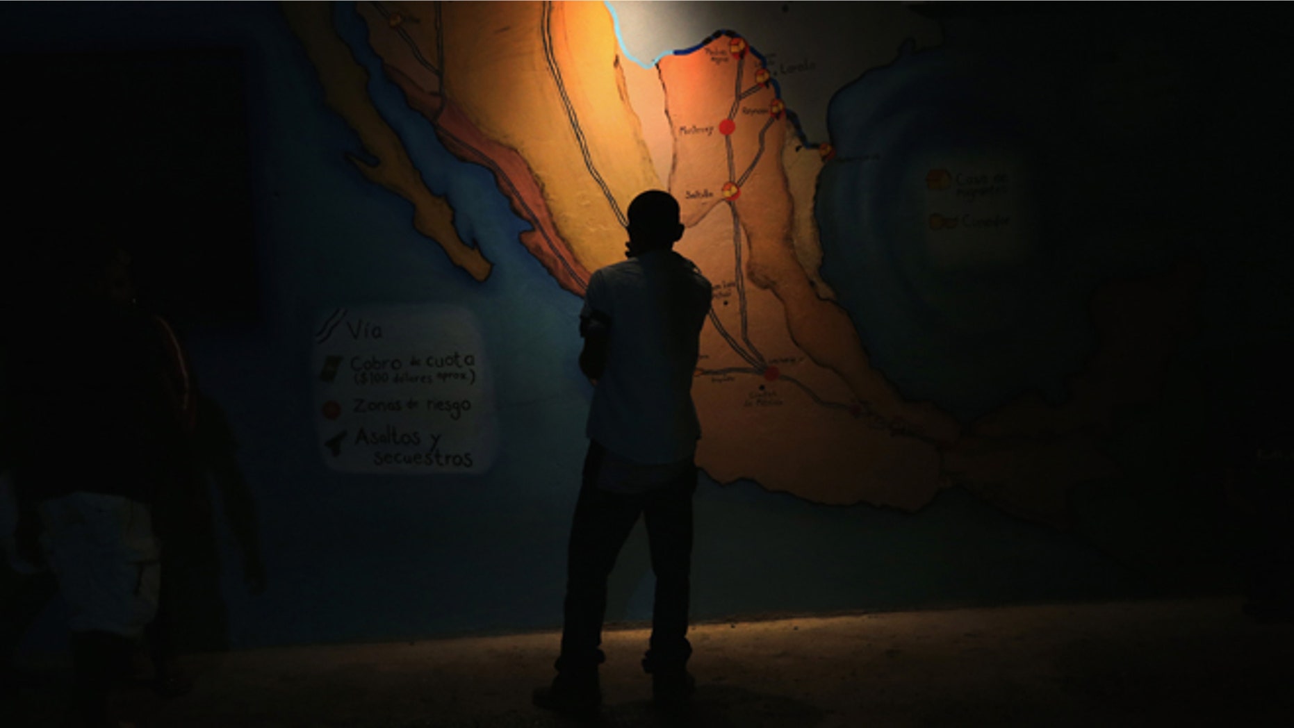 A Honduran immigrant inspects map of Mexico showing train routes leading north at a shelter for undocumented immigrants on September 14, 2014 in Tenosique, Mexico.(Photo by John Moore/Getty Images)