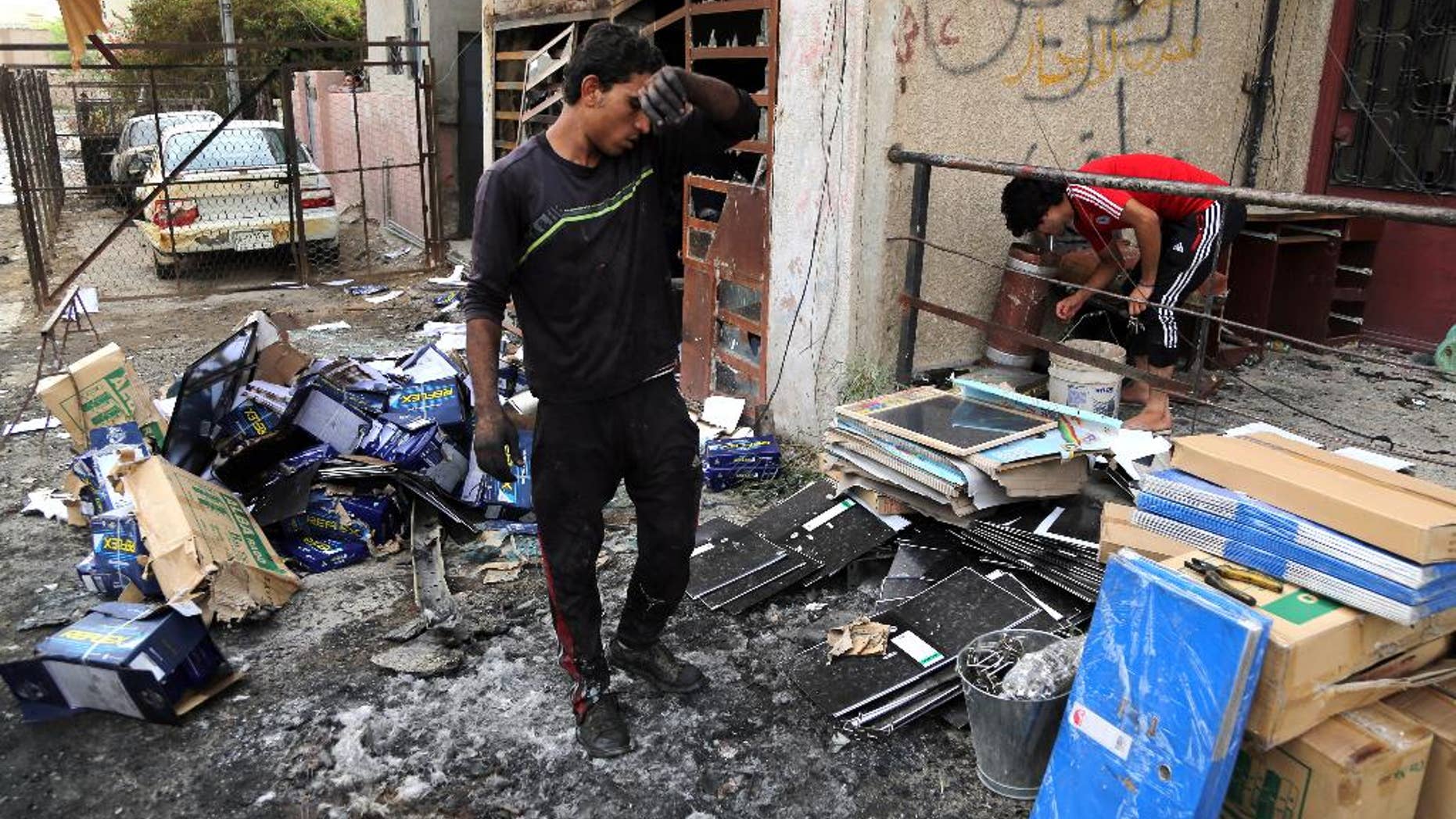 Iraqis clean up the site of a car bomb near restaurants and shop in Palestine Street in eastern Baghdad, Iraq, Wednesday, June 10, 2015. On Tuesday night, a series of bombings targeting public places and Iraqi security forces killing and wounding civilians. (AP Photo/Karim Kadim)