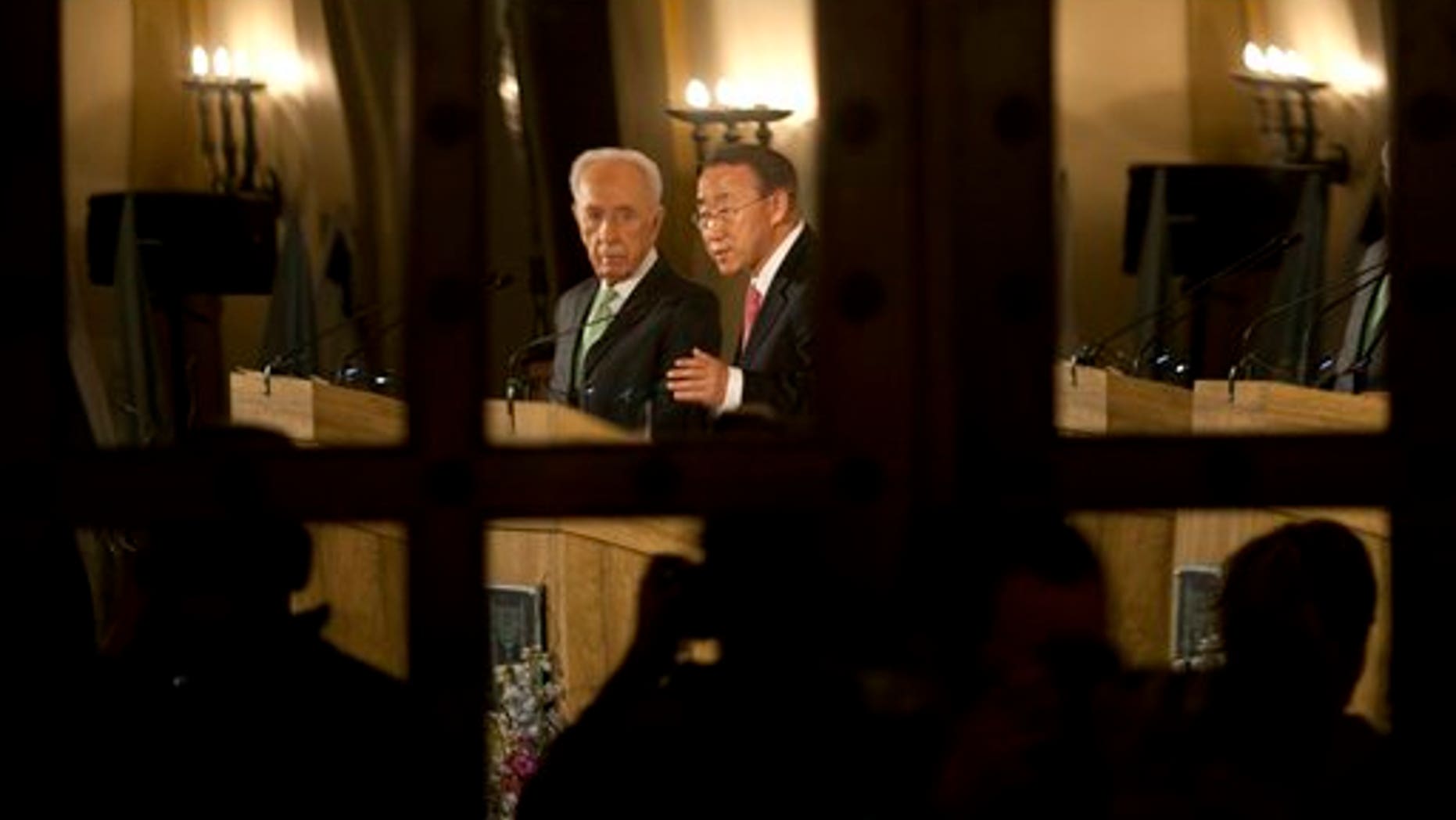 Feb. 1: Israel's President Shimon Peres, left, and United Nations Secretary General Ban Ki-moon are seen reflected in a door's mirror as they speak during a joint news conference at a Jerusalem hotel.