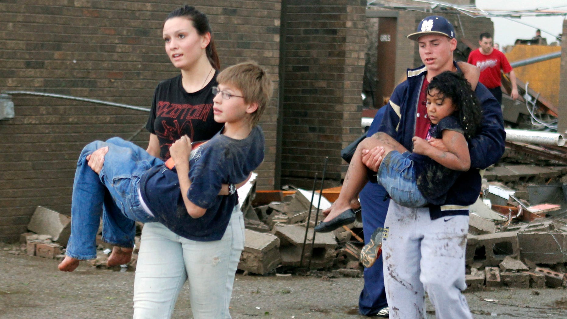 Teachers carry children away from Briarwood Elementary school after a tornado destroyed the school in south Oklahoma City, Okla, Monday, May 20, 2013. Near SW 149th and Hudson. (AP Photo/ The Oklahoman, Paul Hellstern)