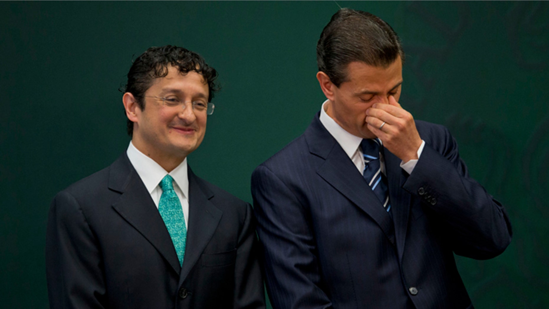 Mexican President Enrique Pena Nieto, right, stands with Virgilio Andrade Martinez, during a press conference to announce Andrade's appointment as the Secretary of Public Administration, in Mexico City, Tuesday, Feb. 3, 2015. Pena Nieto said Tuesday he has asked the Public Administration Department to investigate the purchases of luxury homes, by himself, his wife and his finance secretary, from government contractors. (AP Photo/Rebecca Blackwell)