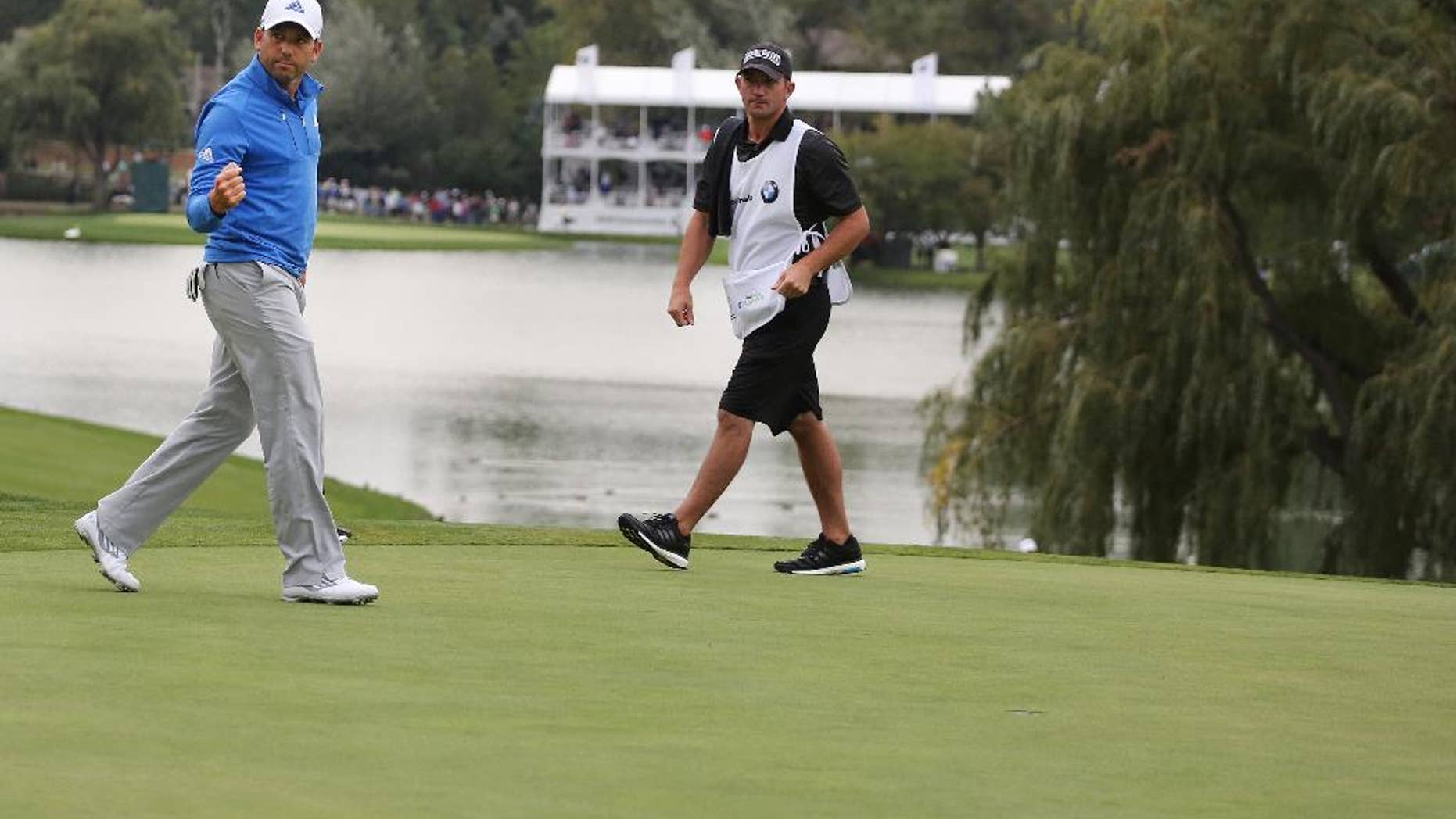 Sergio Garcia, left, of Spain, reacts after sinking his putt on the 18th hole for a birdie during the second round of the BMW Championship golf tournament at Cherry Hills Country Club in Cherry Hills Village, Colo., Friday, Sept. 5, 2014. (AP Photo/Brennan Linsley)