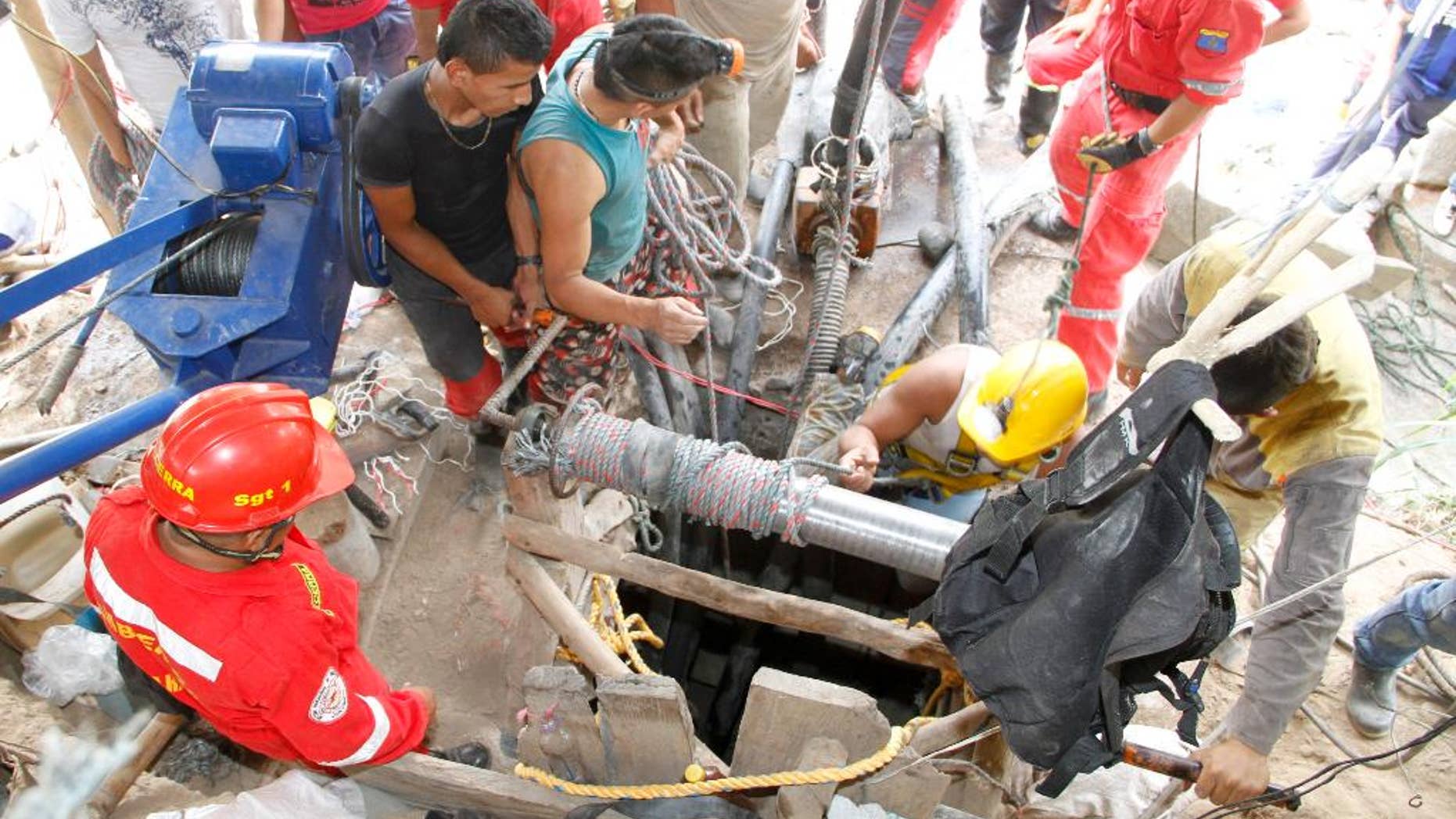 Miners and rescue workers work at the entrance to the El Tunel gold mine in Riosucio, Colombia, Wednesday, May 13, 2015. Fifteen miners are missing and feared dead after water poured into the underground shafts where they were digging early Wednesday. Authorities said the accident was likely triggered by an explosion or power outage that disabled pumps used to extract water and supply oxygen to work crews. (AP Photo/Juan Augusto Cardona)