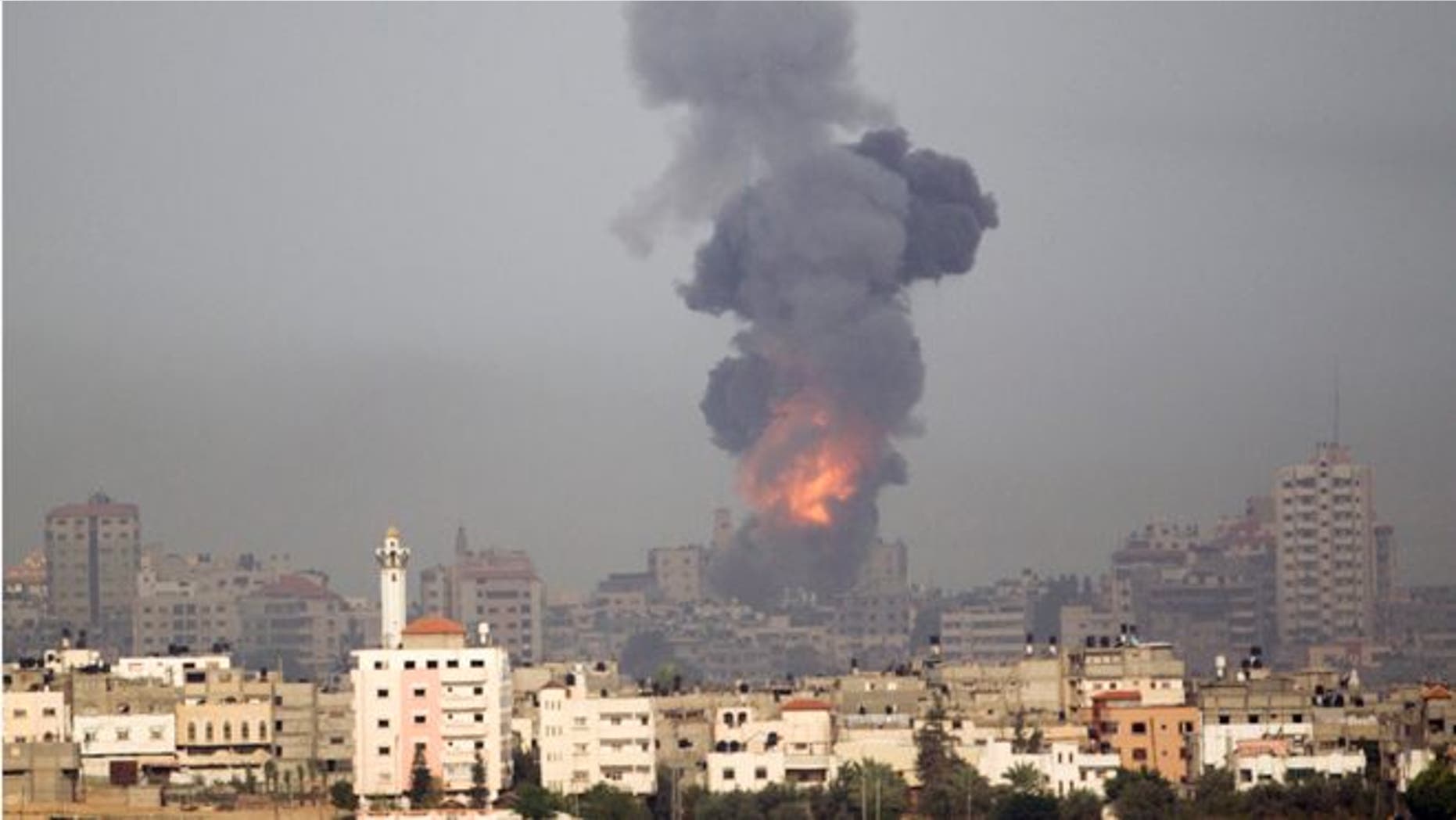 Explosion and smoke rise following an Israeli strike in Gaza, seen from the Israel Gaza Border, southern Israel, Saturday, Nov. 17, 2012. Israel bombarded the Hamas-ruled Gaza Strip with more than 180 airstrikes early Saturday, the military said, widening a blistering assault on militant operations to include the prime minister's headquarters, a police compound and a vast network of smuggling tunnels. The new attacks followed an unprecedented rocket strike aimed at the contested holy city of Jerusalem that raised the stakes in Israel's violent confrontation with Palestinian militants. (AP Photo/Ariel Schalit)