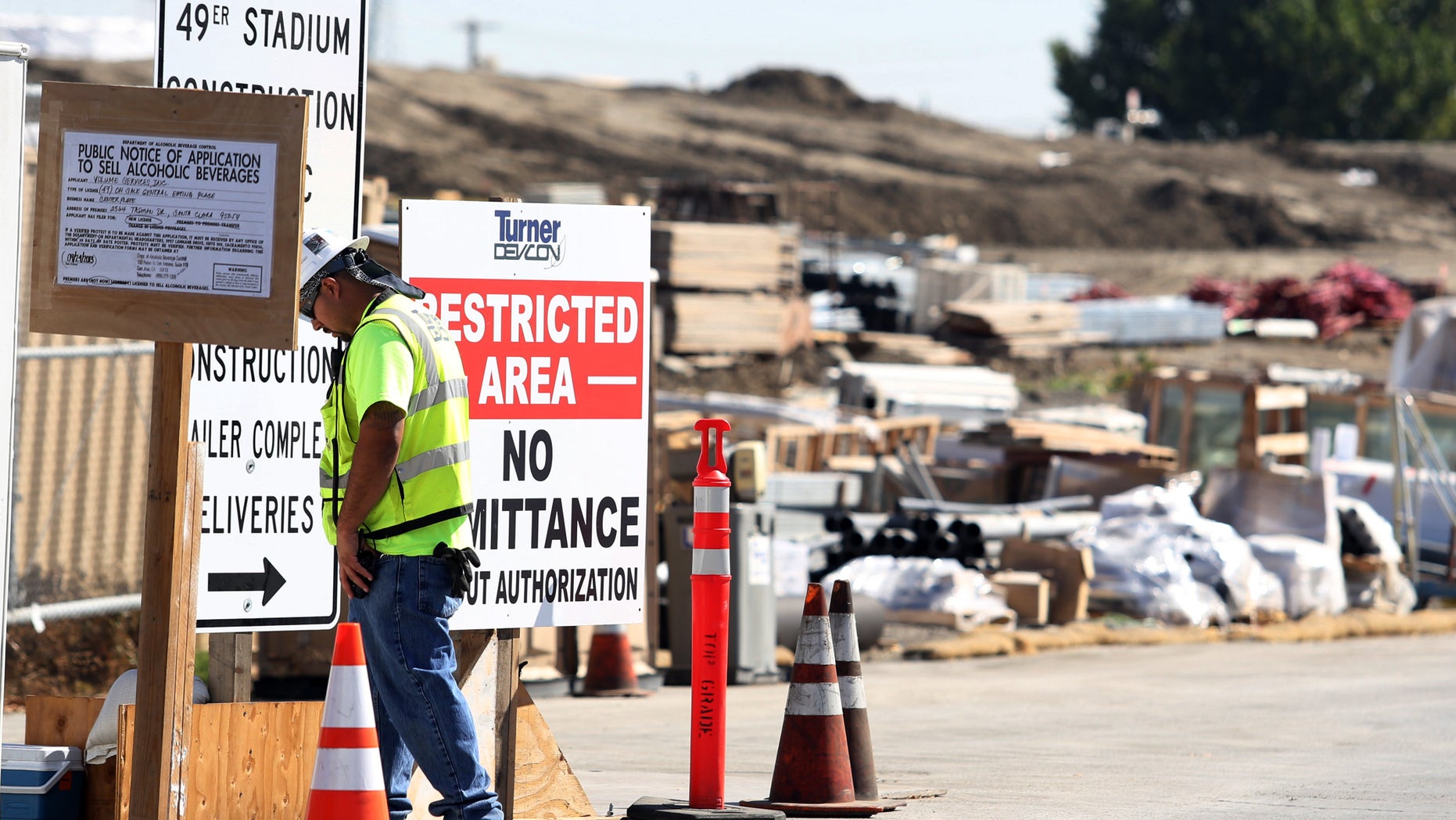 A security guard walks by a construction entrance at the Forty-Niners' new stadium Monday, Oct. 14, 2013, in Santa Clara, Calif., where a second worker has been killed in an accident in less than four months. A delivery truck driver was crushed early Monday by a bundle of rebar being unloaded from his truck, officials at the scene said. (AP Photo/Mathew Sumner)
