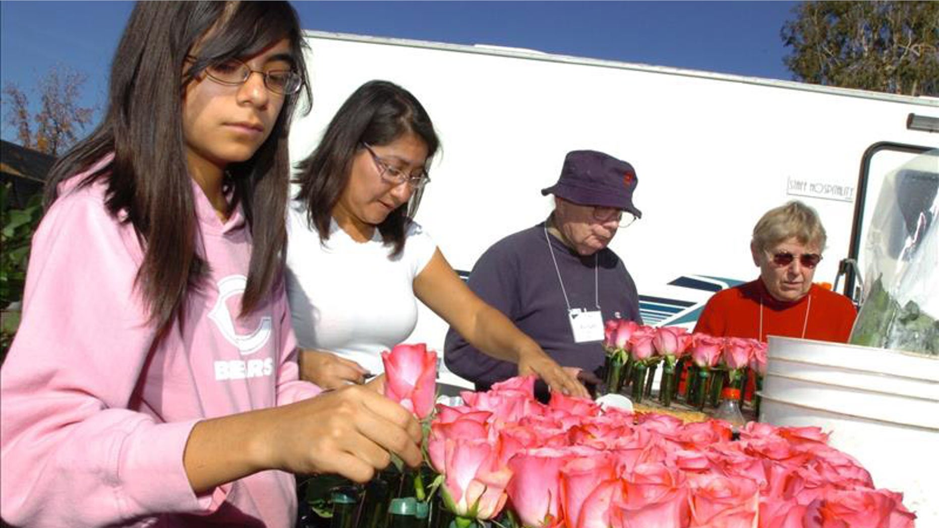 Natalie Benavides (left) and her mother, Marcy, attach roses to one of the floats for the Tournament of Roses Parade. EFE/File