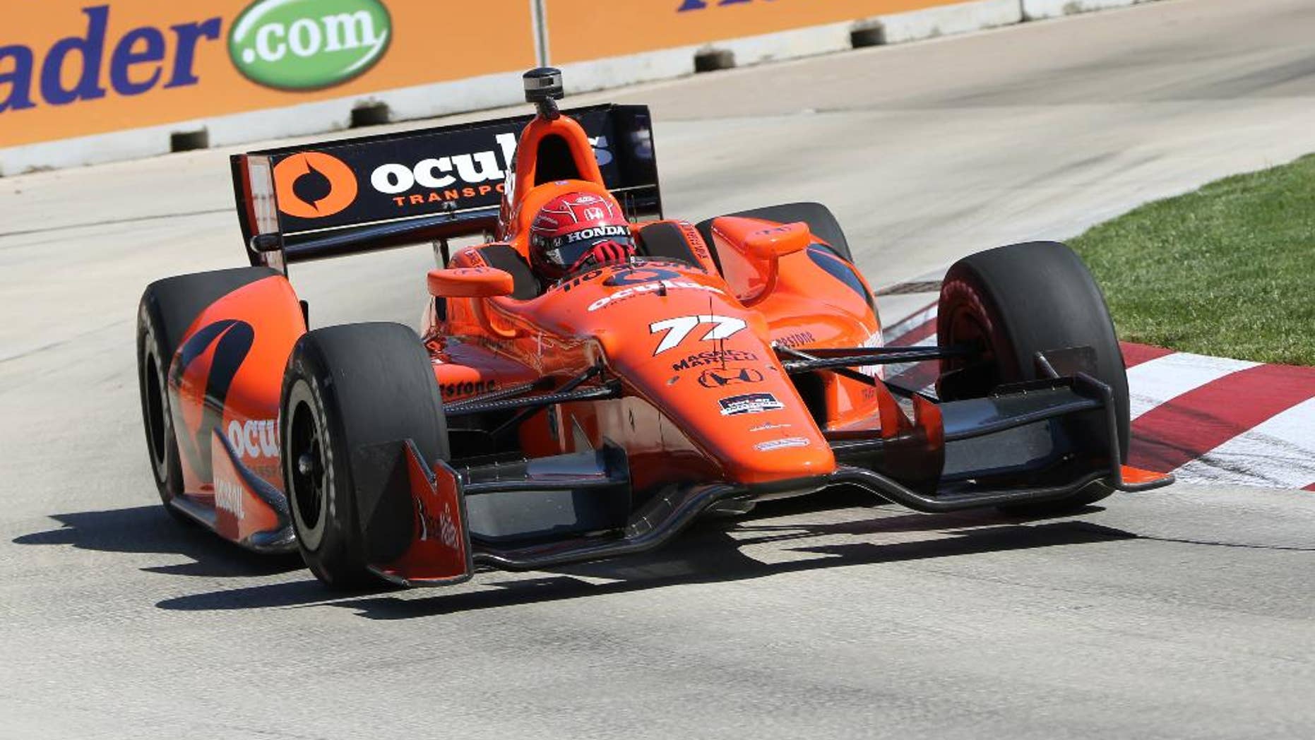 Simon Pgenaud takes a turn during a practice session for the IndyCar Detroit Grand Prix auto race on Belle Isle in Detroit, Friday, May 30, 2014. (AP Photo/Bob Brodbeck)