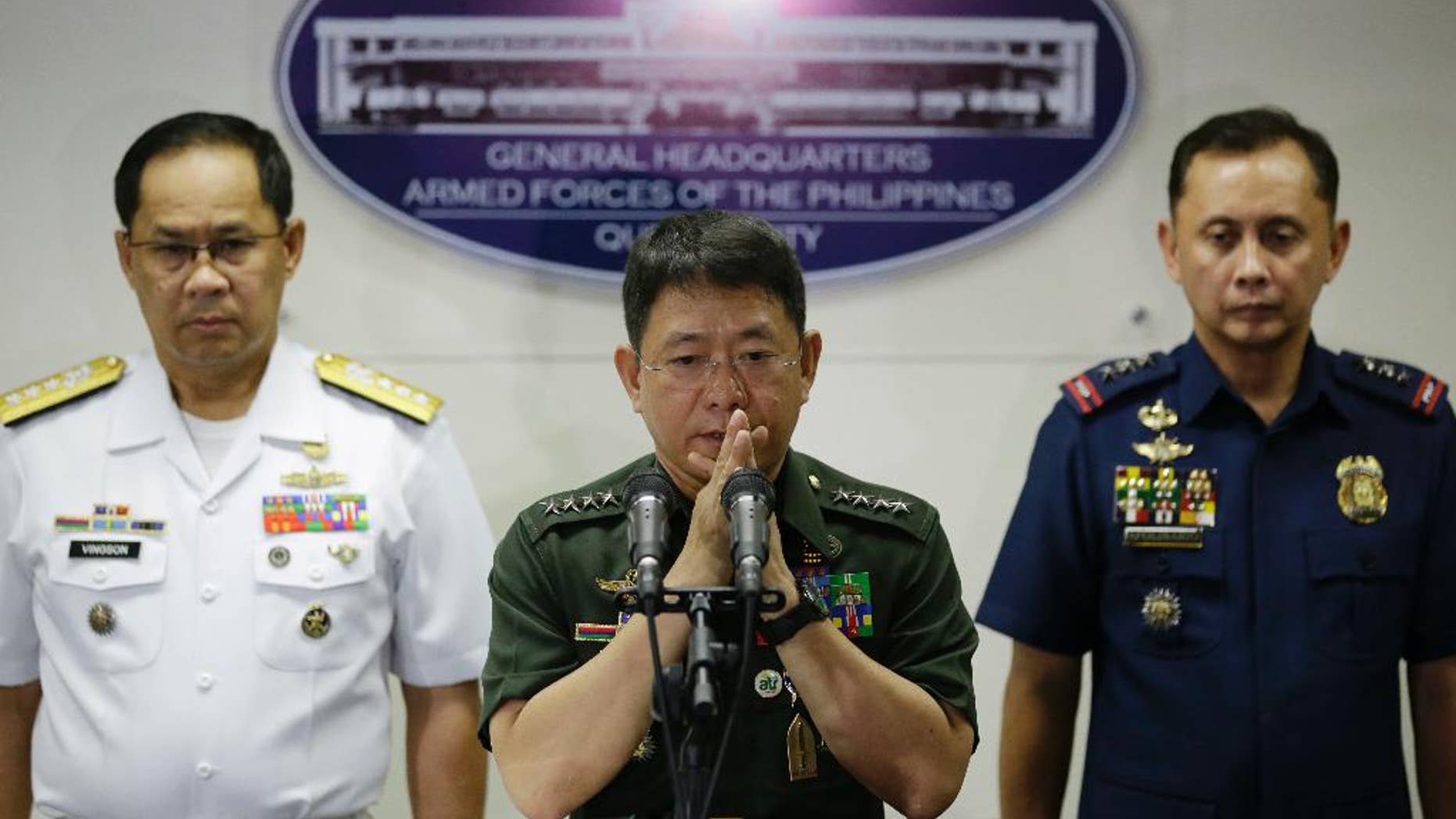 Philippine military chief of staff Gen. Eduardo Ano, center, gestures beside Philippine Navy Vice Adm. Narciso Vingson, left, and Philippine National Police Deputy Director for Administration Ramon Apolinario during a press conference at Camp Aguinaldo, the military headquarters in Quezon city, north of Manila, Philippines, Wednesday, April 12, 2017. Philippine troops battling militants in a central province killed a key Abu Sayyaf commander who had been blamed for the beheadings of two Canadians and a German hostage and was apparently attempting another kidnapping mission, Ano said Wednesday. (AP Photo/Aaron Favila)