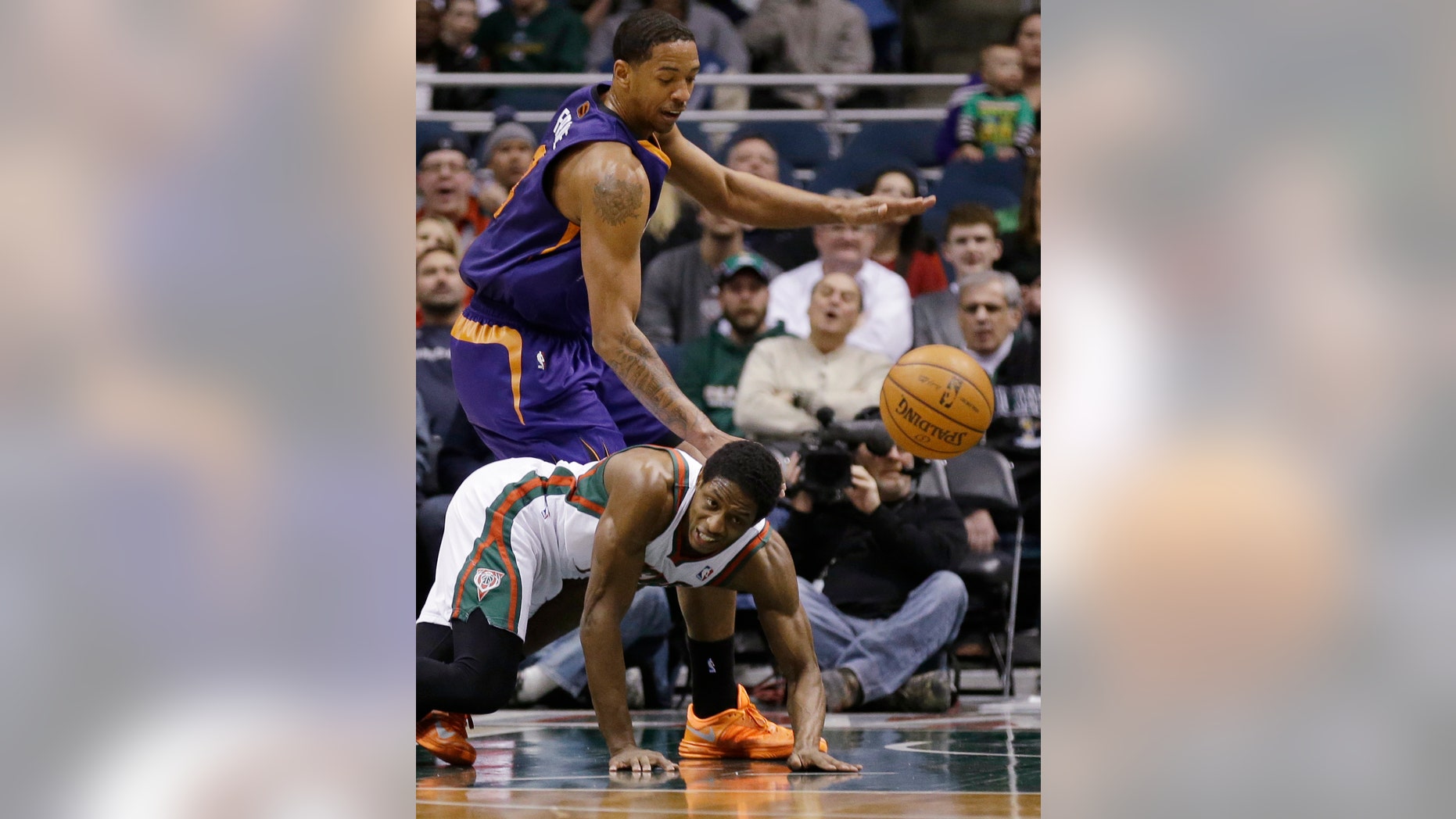 Milwaukee Bucks' Brandon Knight, bottom, and Phoenix Suns' Channing Frye watch a loose ball during the first half of an NBA basketball game Wednesday, Jan. 29, 2014, in Milwaukee. (AP Photo/Jeffrey Phelps)