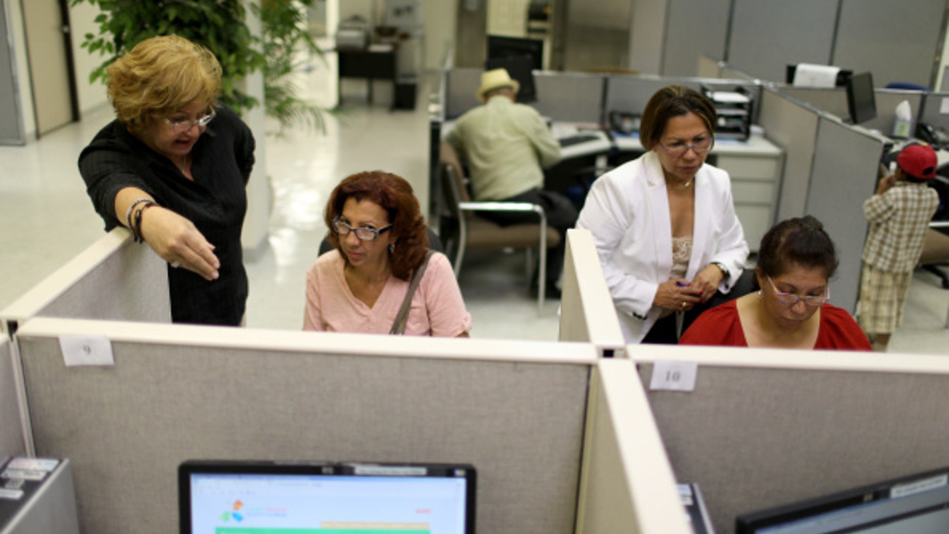 MIAMI, FL - AUGUST 01: Raisa Alvarez (L) helps Ana Celeste Reynoso as Maria Tutiven (2nd R) helps Idali Valasquez as they look for job opportunities on the computers at CareerSource Florida on August 1, 2014 in Miami, Florida. The Labor Department announced that U.S. employers added 209,000 new jobs in July and that the unemployment rate edged up to 6.2 percent as more workers joined the labor force. (Photo by Joe Raedle/Getty Images)