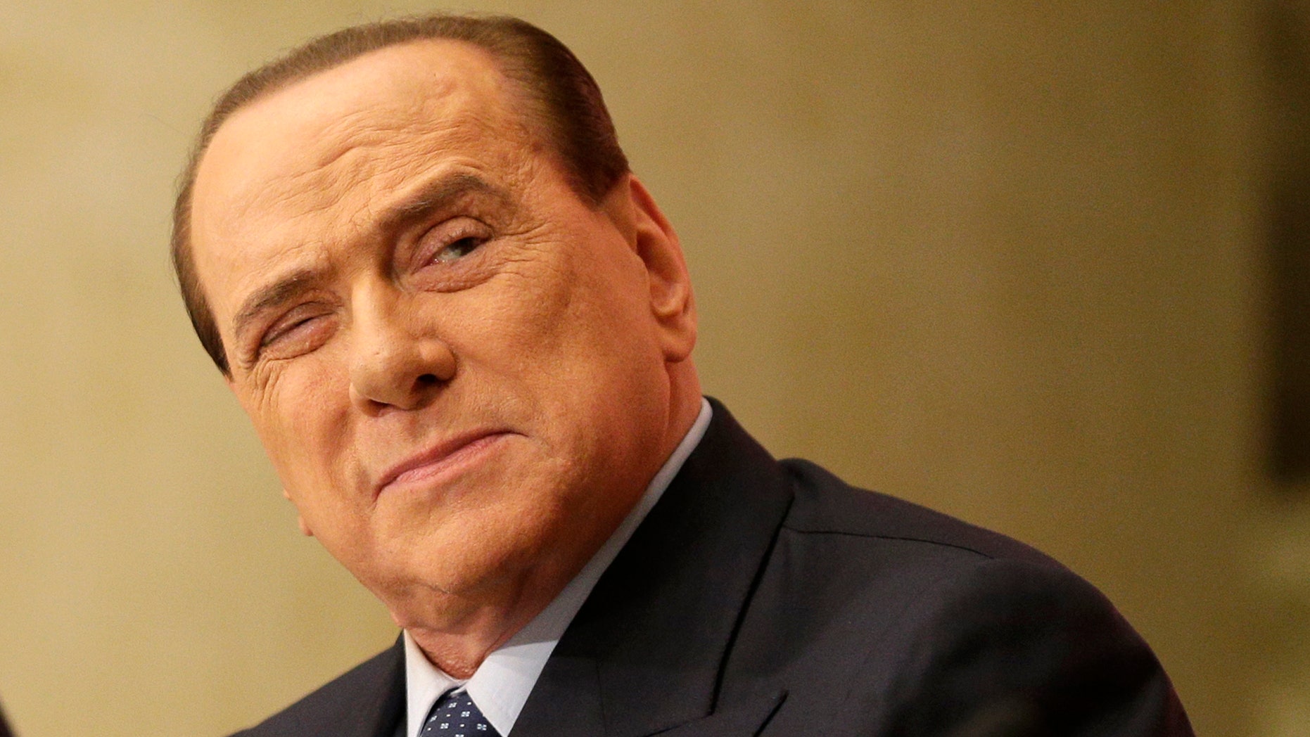 In this Dec. 4, 2013 photo former Premier Silvio Berlusconi attends the launch of a book "Sale, zucchero e caffe'" (Salt, Sugar and Coffee) by his friend, journalist Bruno Vespa, in Rome. Berlusconi's political corruption trial has opened in the southern city of Naples on Tuesday, Feb. 11, 2014, yet another legal challenge for the three-time former premier. Berlusconi is accused of paying a senator 3 million euros (4 million US dollars) to a bolt a rival government, which eventually fell. (AP Photo/Alessandra Tarantino)