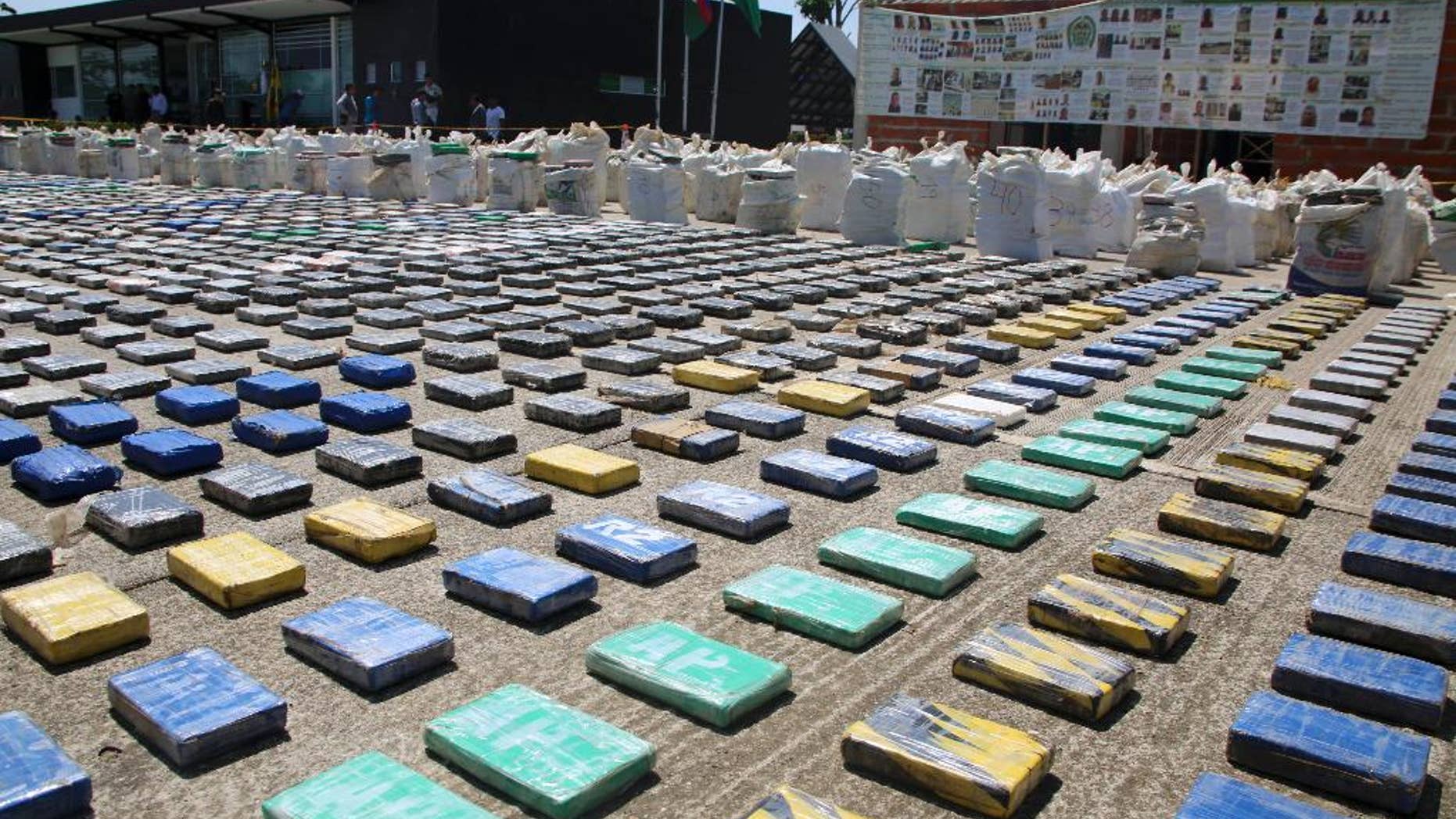 This photo released by Colombia's National Police shows packages of cocaine on display in Necocli, in the northwestern state of Antioquia, Colombia, Sunday, May 15, 2016. The National Police agency said commandos backed by helicopters seized about eight tons of cocaine on a banana plantation belonging to a gang known as the Clan Usuaga and was apparently destined for the Caribbean and then to the United States. Authorities say its the biggest cocaine seizure in Colombia's history. (Colombia National Police via AP)