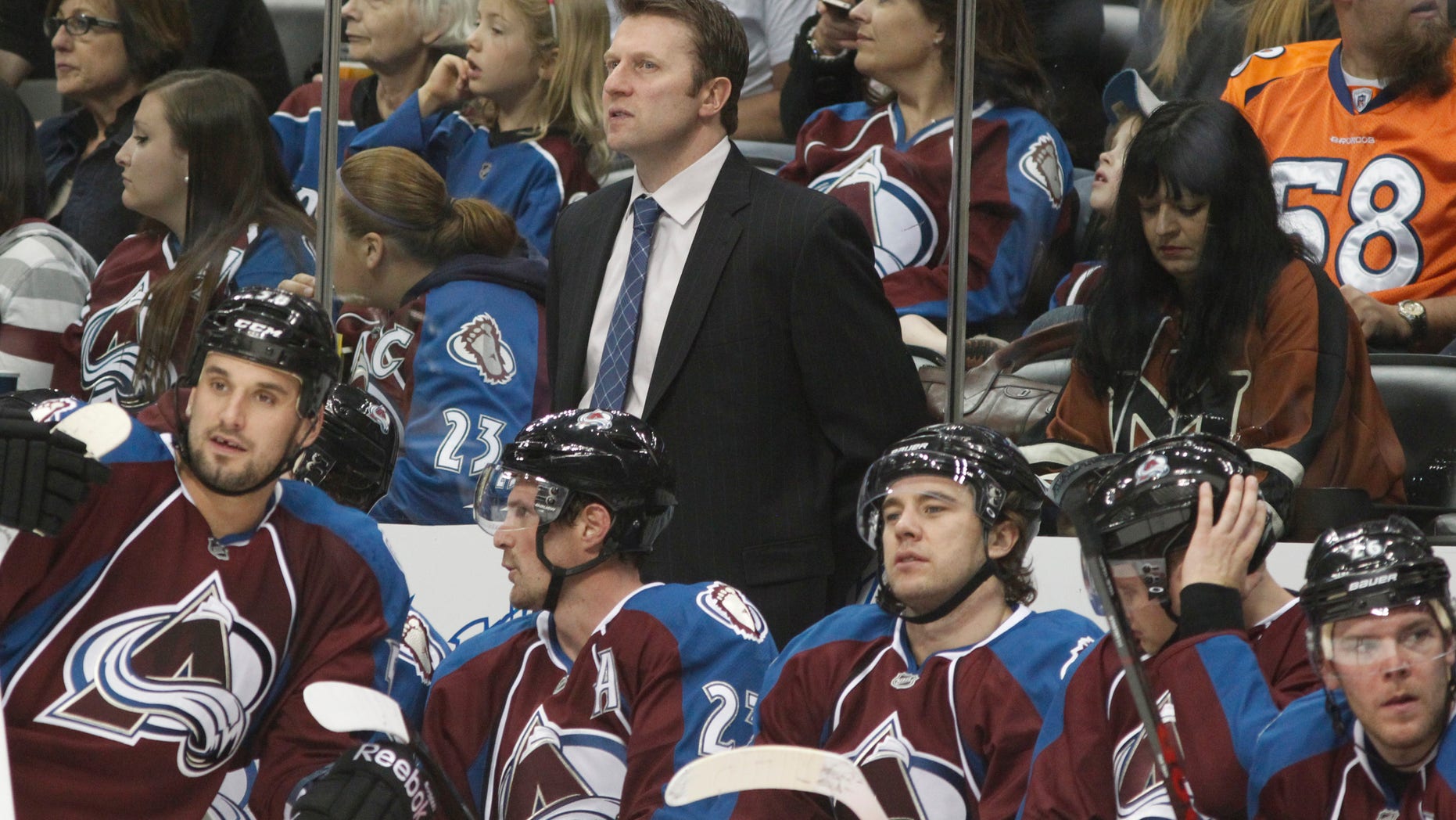Colorado Avalanche head coach Joe Sacco, back, looks on as his players take a break during a time out against the Minnesota Wild in the second period of an NHL hockey game in Denver on Saturday, April 27, 2013. (AP Photo/David Zalubowski)